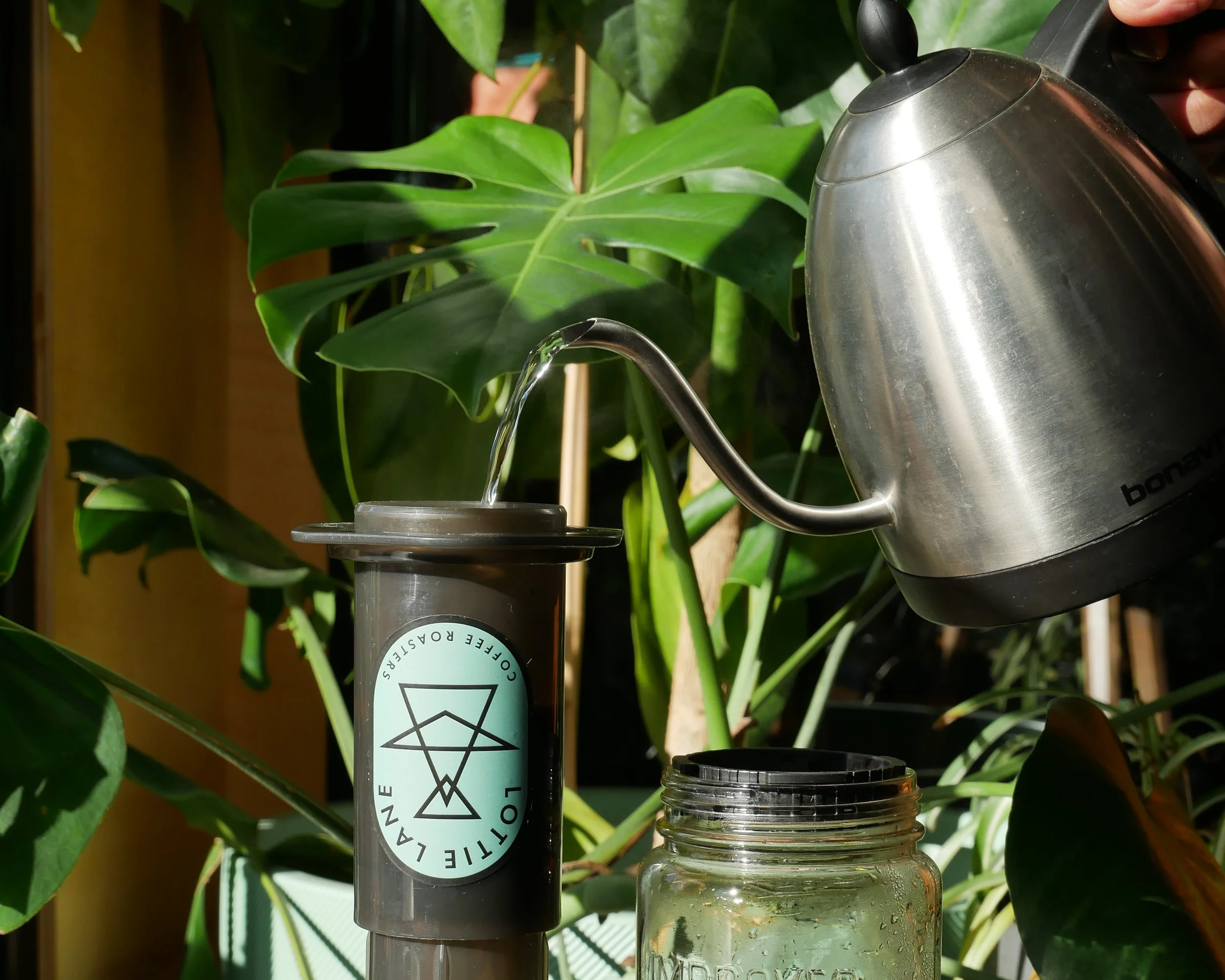 A kettle pouring hot water into the top of an Aeropress