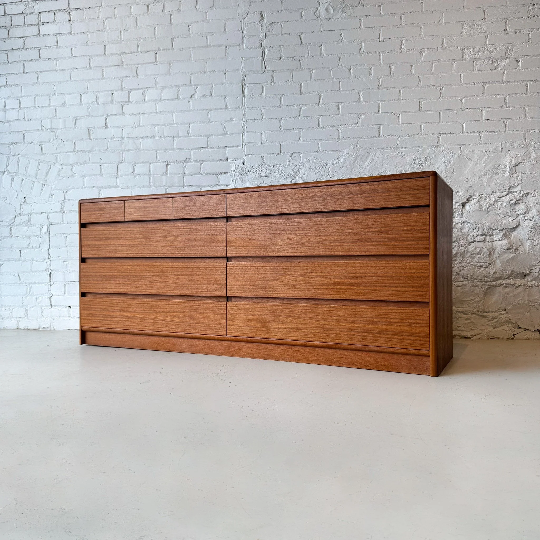 Next up, we have a Dyrlund Danish Teak dresser available! 
With seven large drawers and three small ones you'll be able to easily stay organized. The gorgeous teak wood of this dresser is emphasized with sleek rounded corners and dovetail drawer cons