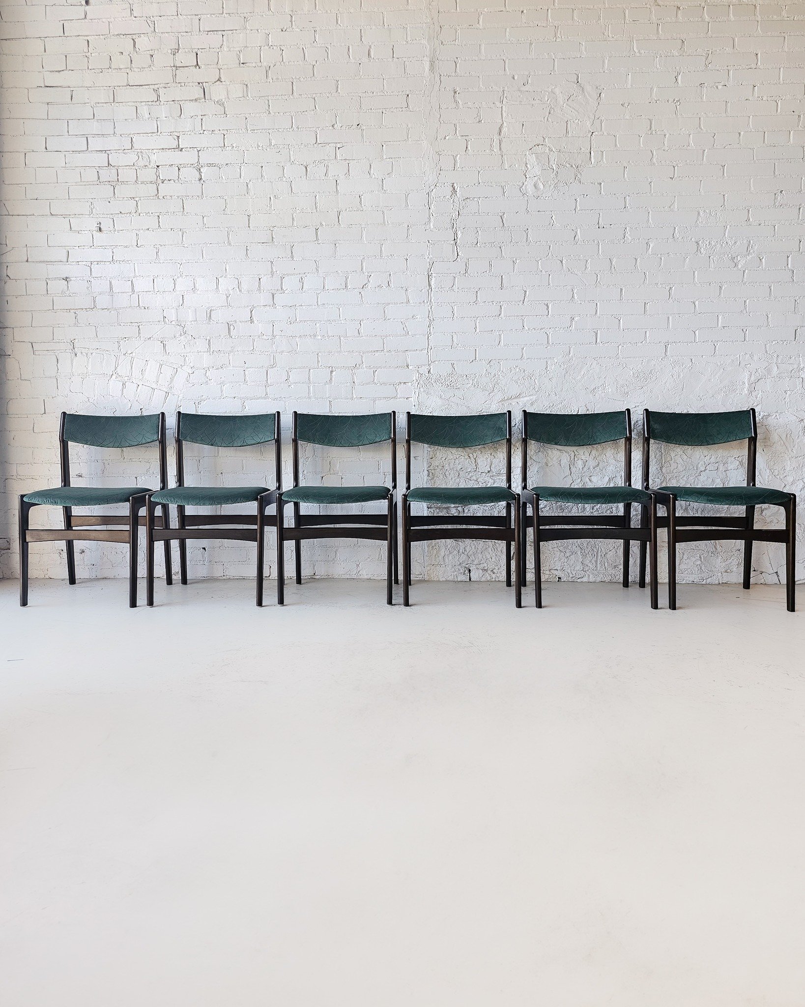 Meet your new dinner party MVPs.
This stunning set of six Erik Buch Model 49–inspired dining chairs brings serious mood to the table—literally. With sculptural rosewood frames and freshly reupholstered, ultra-plush velvet seats, these ch