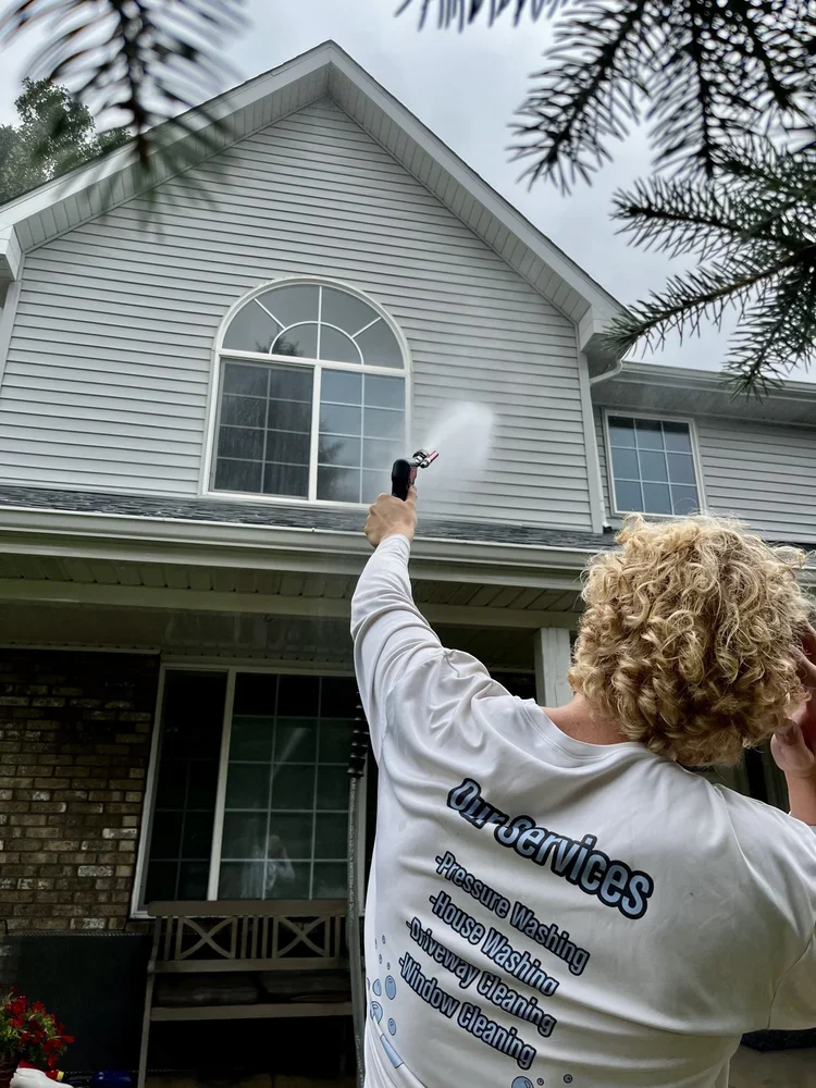 Professional pressure washing service cleaning second-story siding in Dewitt MI