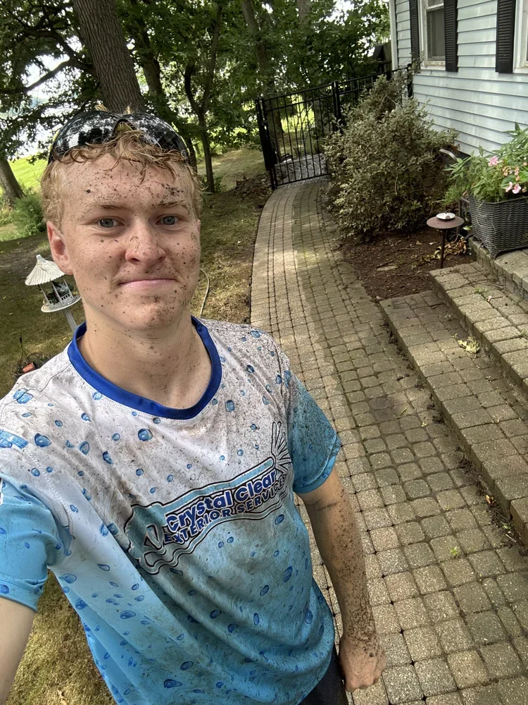 Crystal Clear Exterior Services technician after completing paver patio pressure washing in Haslett MI.