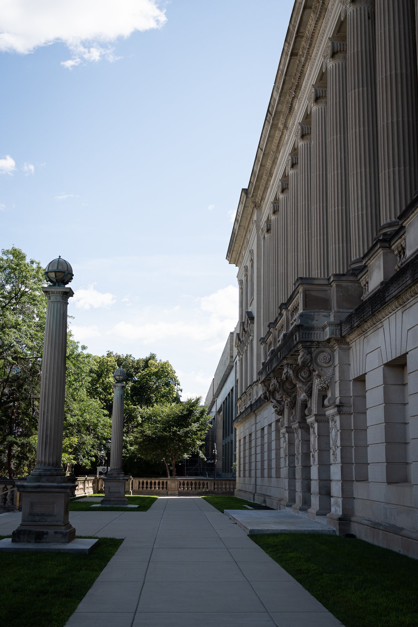 Photo of a stone building with fluted columns set against blue sky