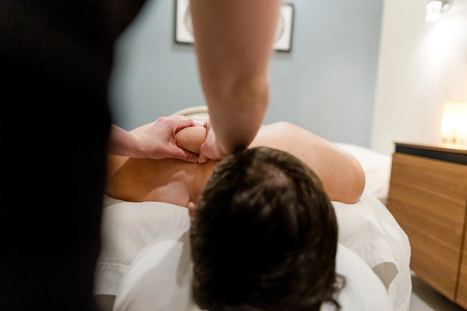 Professional sports massage therapist performing a deep tissue massage on an athlete's leg to relieve muscle tension and enhance performance.