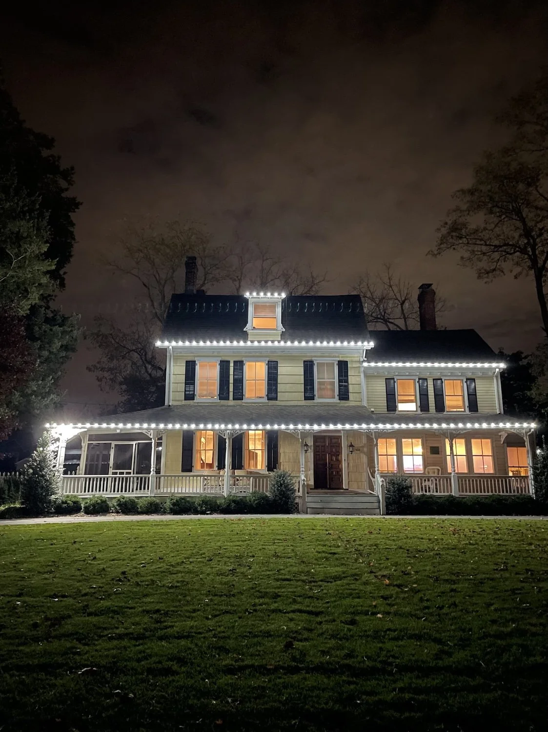 House outline illuminated with pure white Christmas lights.