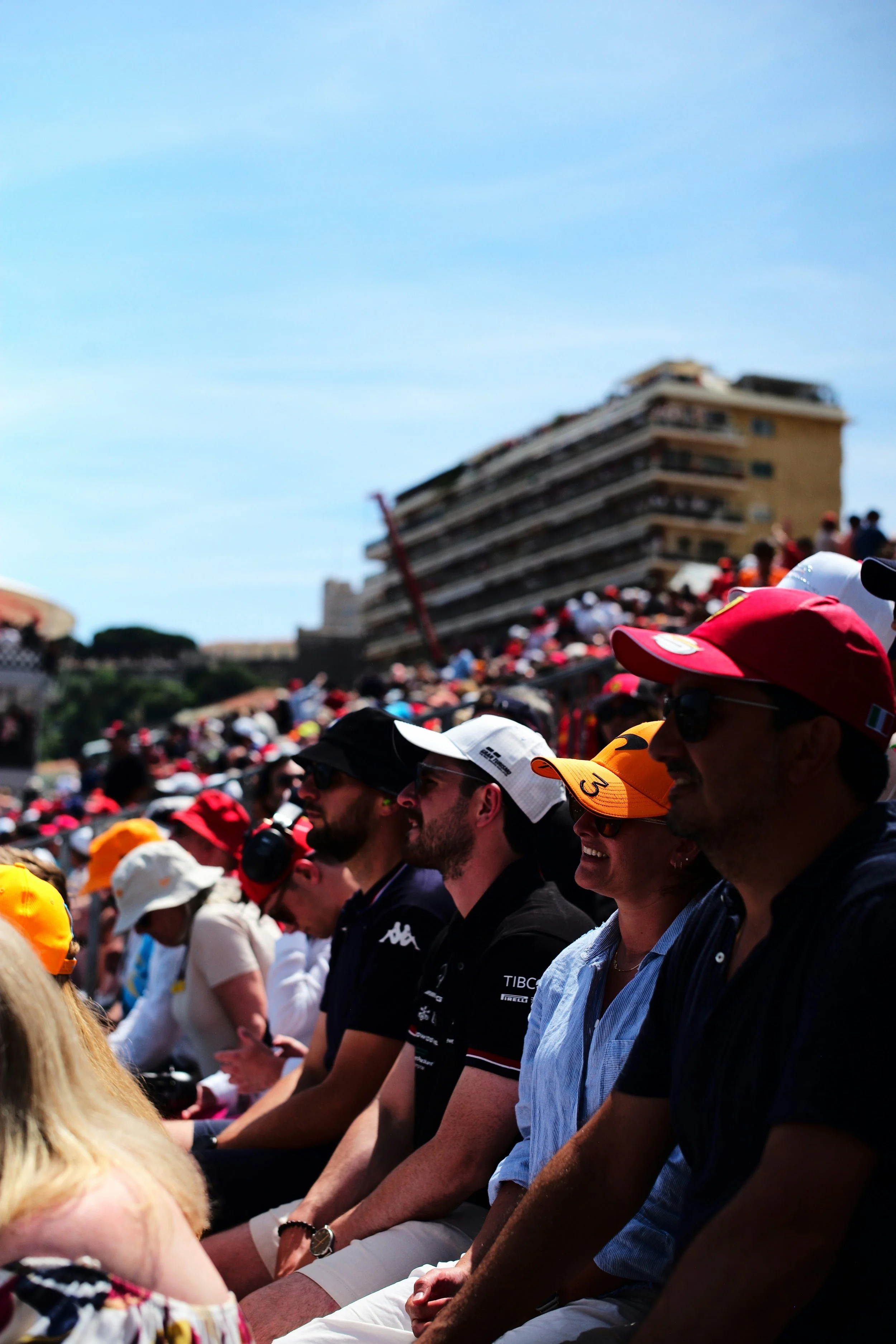 Formula 1 fans watching race from grandstand, showing live fan engagement and shared audience experience