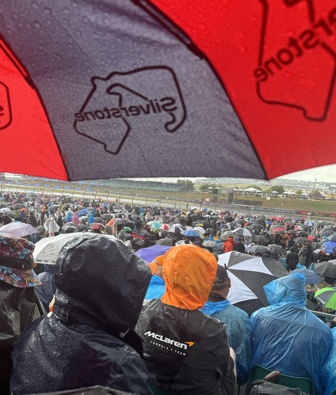 Formula 1 fans watching a wet Grand Prix from the grandstands