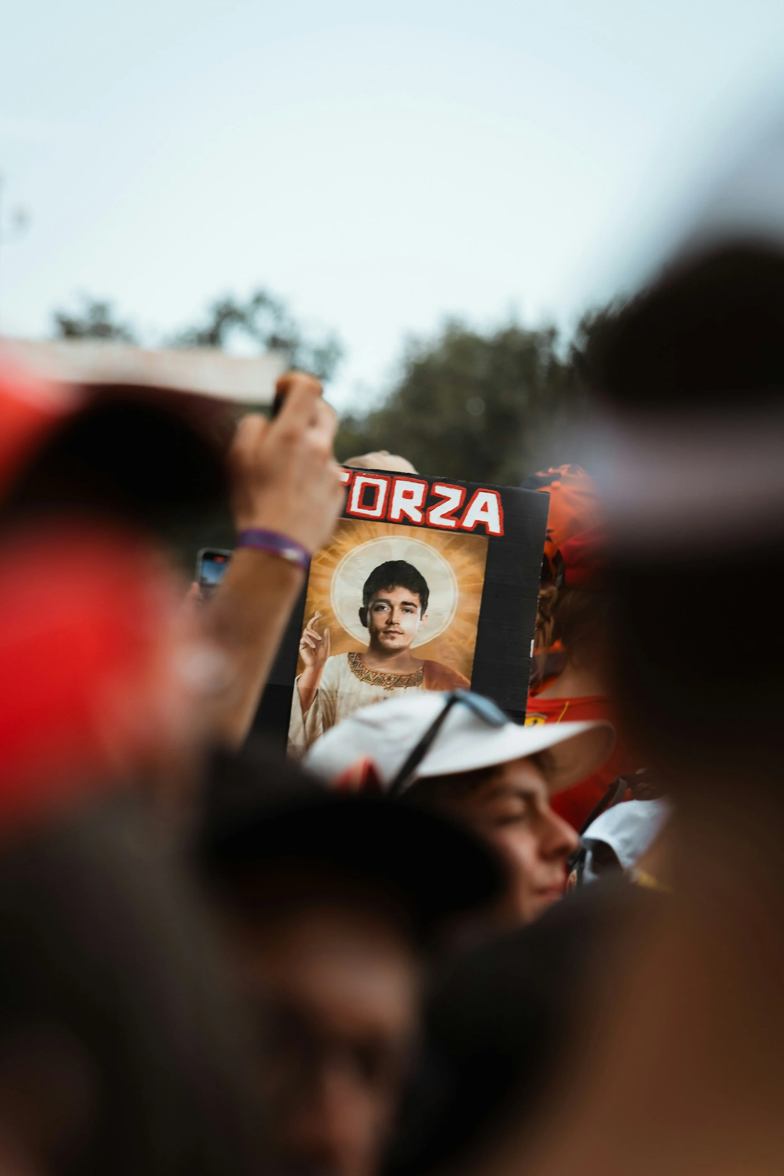 Formula 1 fans holding a Charles Leclerc sign, an example of the reactive moments F1 content creators capture at race weekends