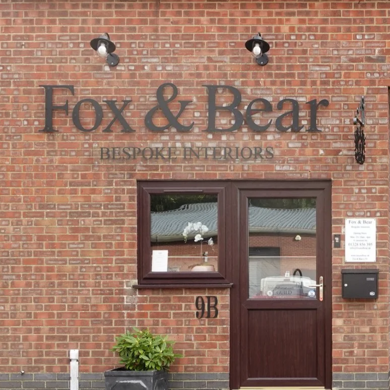 The exterior of our showroom and workshop in Fakenham 9b Millers Close NR21 8NW with a sign that says "Fox & Bear BESPOKE INTERIORS." Bespoke Kitchens and Interiors Personal, Local, Bespoke