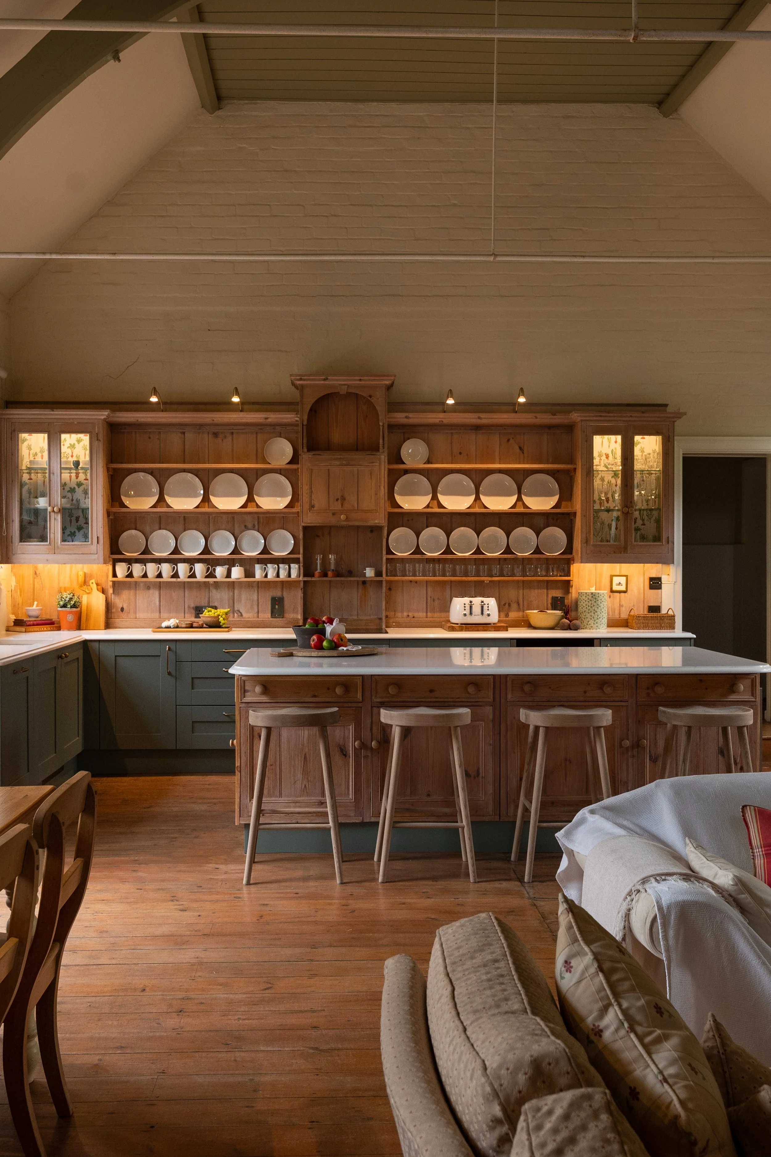 Wide view of the Great Snoring School House kitchen, showing the high vaulted ceiling, retained timber plate rack and reclaimed island.