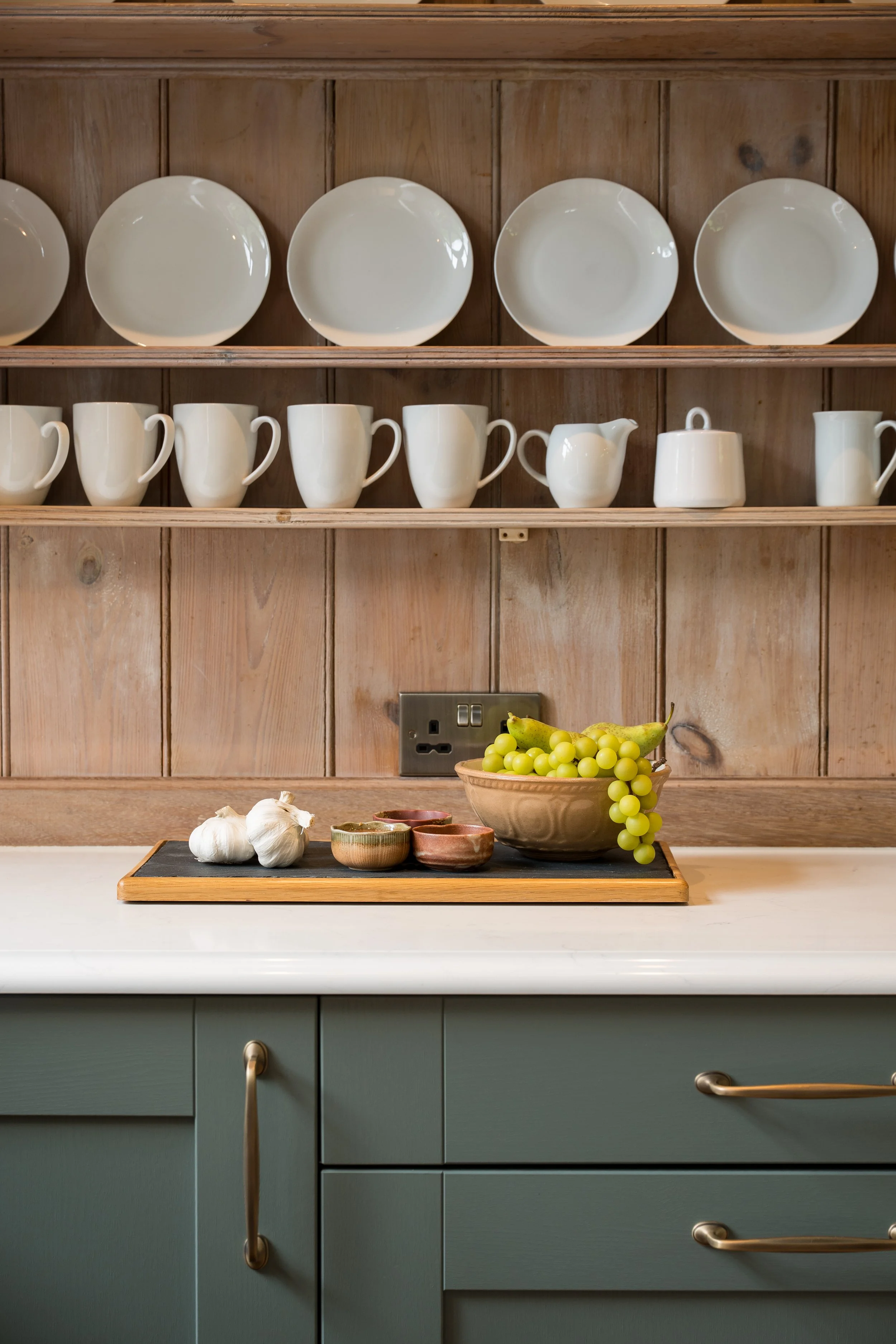 Reed Green Shaker kitchen with retained timber plate rack, Carrara Branco quartz worktops and reclaimed timber island.