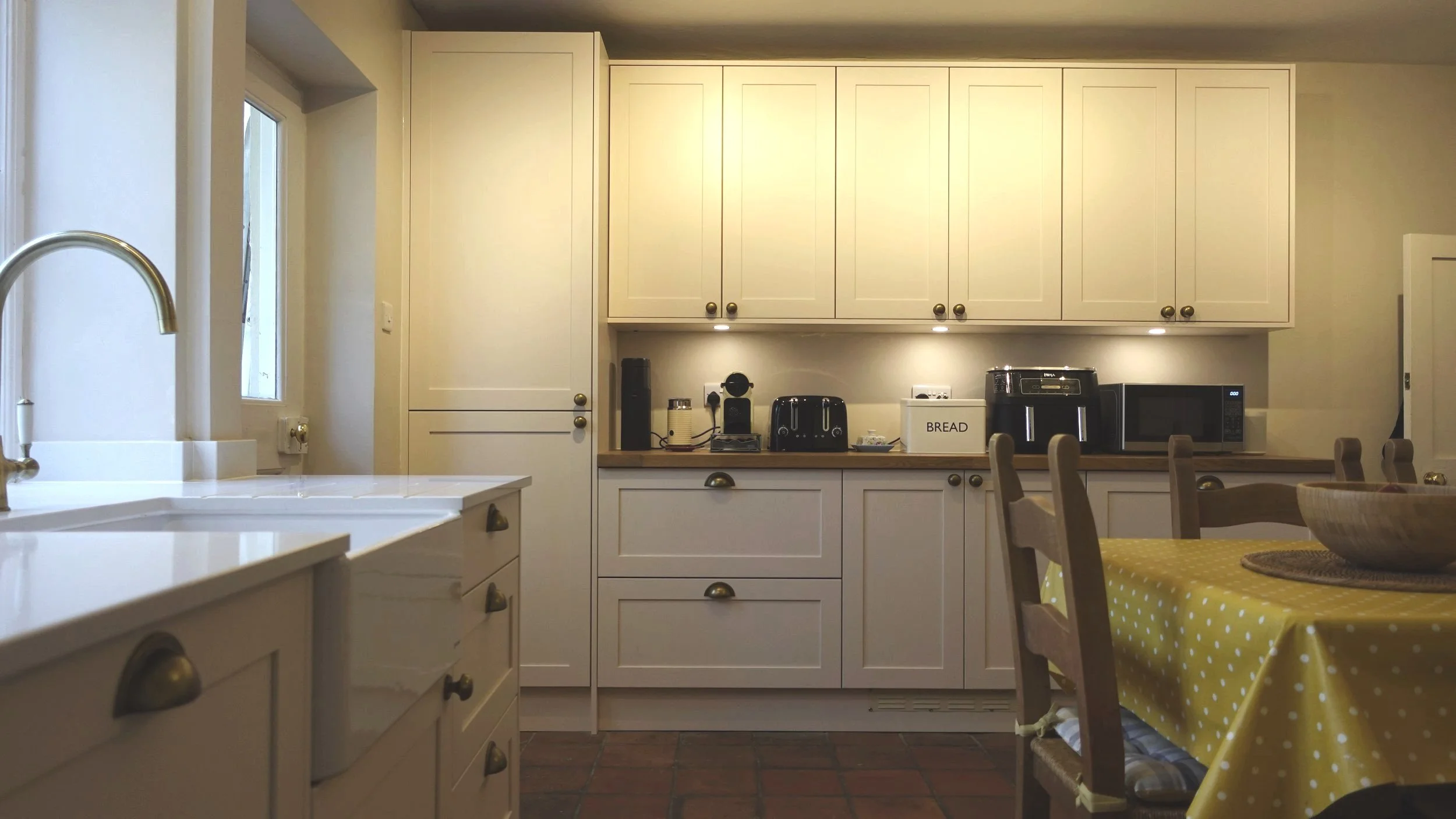 Shaker Hawkshaw range solid ash door painted in Oyster Kitchen with mix of Oak and quartz worktops. Caple sink and tap. Cups and knobs in aged brass. Completed by Fox and Bear, Foulsham Norfolk. 