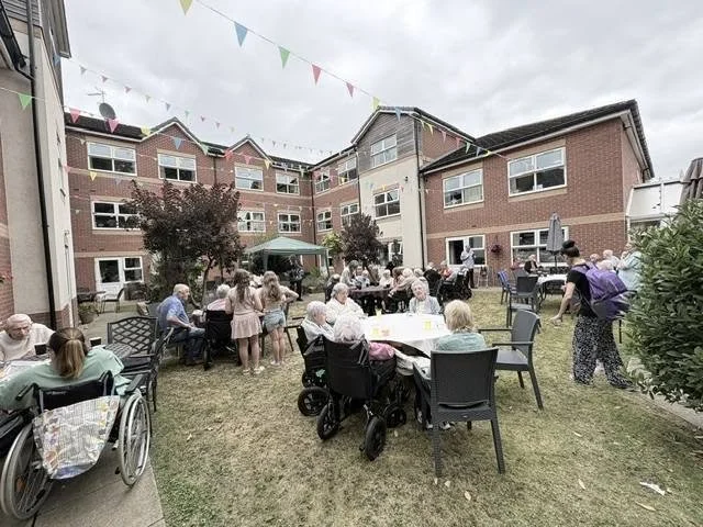 Residents, families and staff in the gardens at Berrycroft Manor care home in Romiley during the annual Garden Party