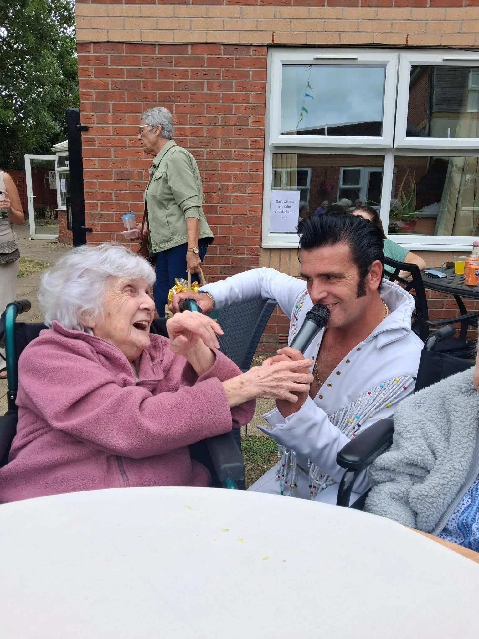 A resident sings along with the Elvis tribute act at the Berrycroft Manor Garden Party in Romiley