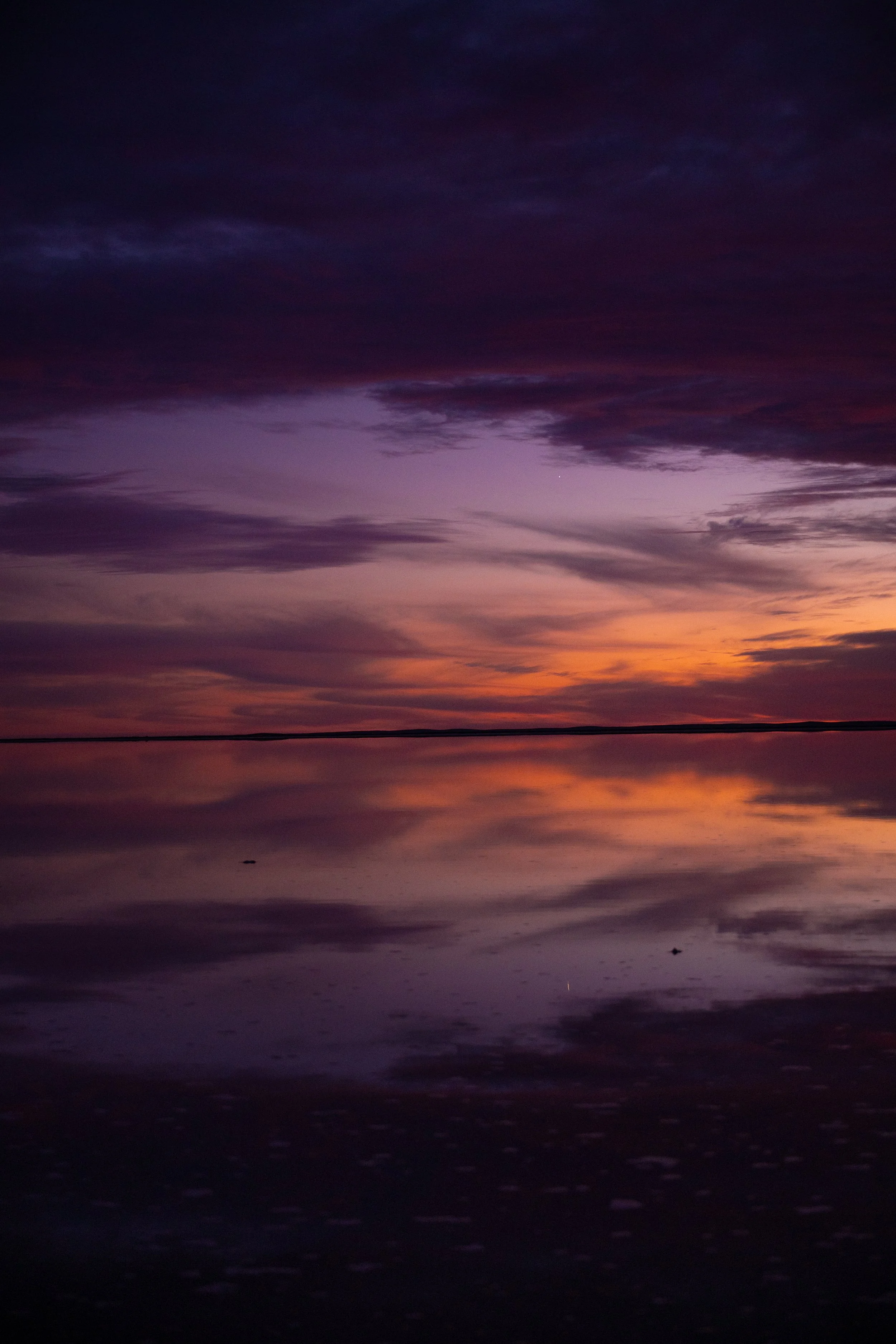     Purple and orange sunset clouds reflected in the still waters of Lake Tyrrell, Victoria.    