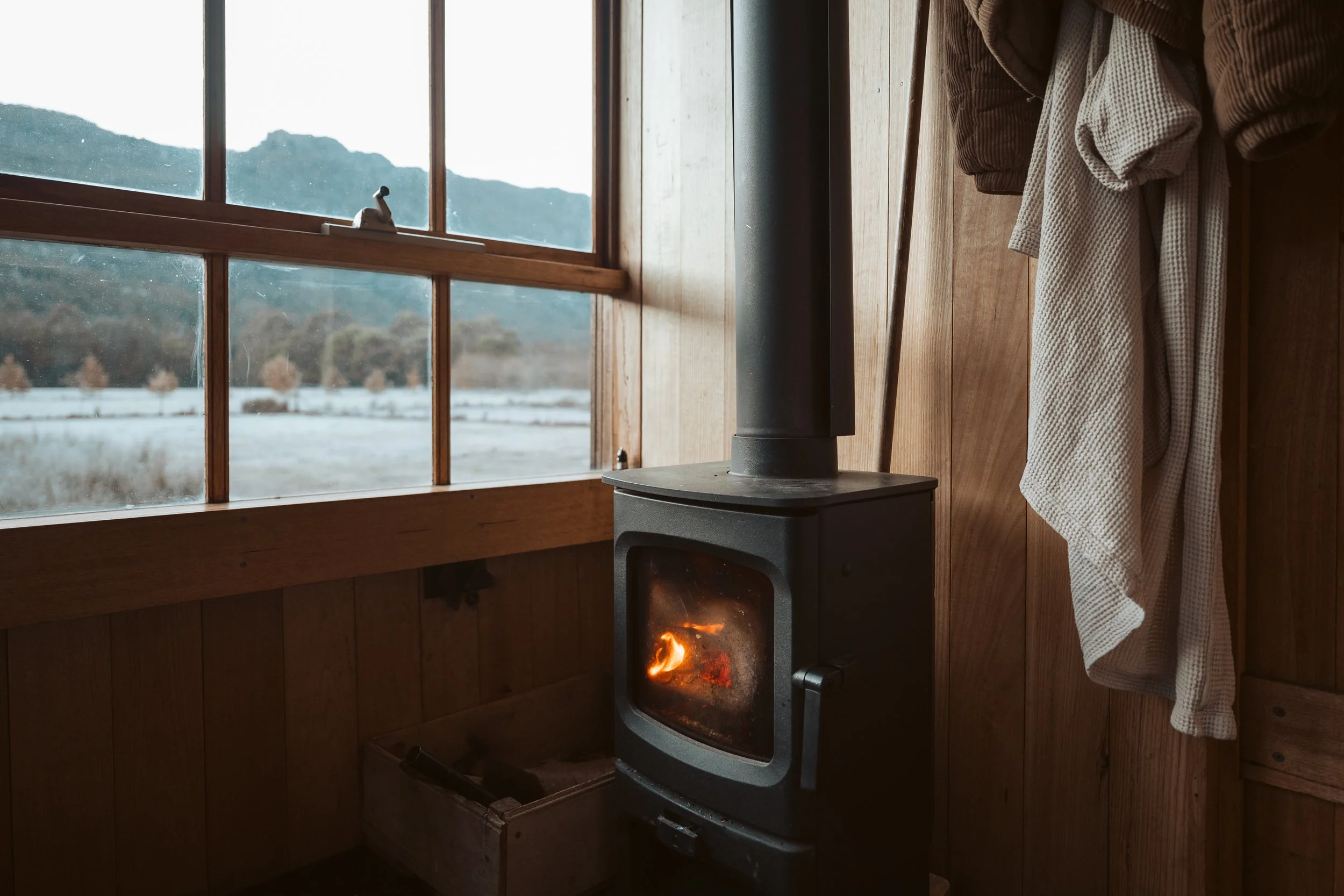   Wood-burning fireplace and warm interior details inside an off-grid tiny hut in the Grampians.  