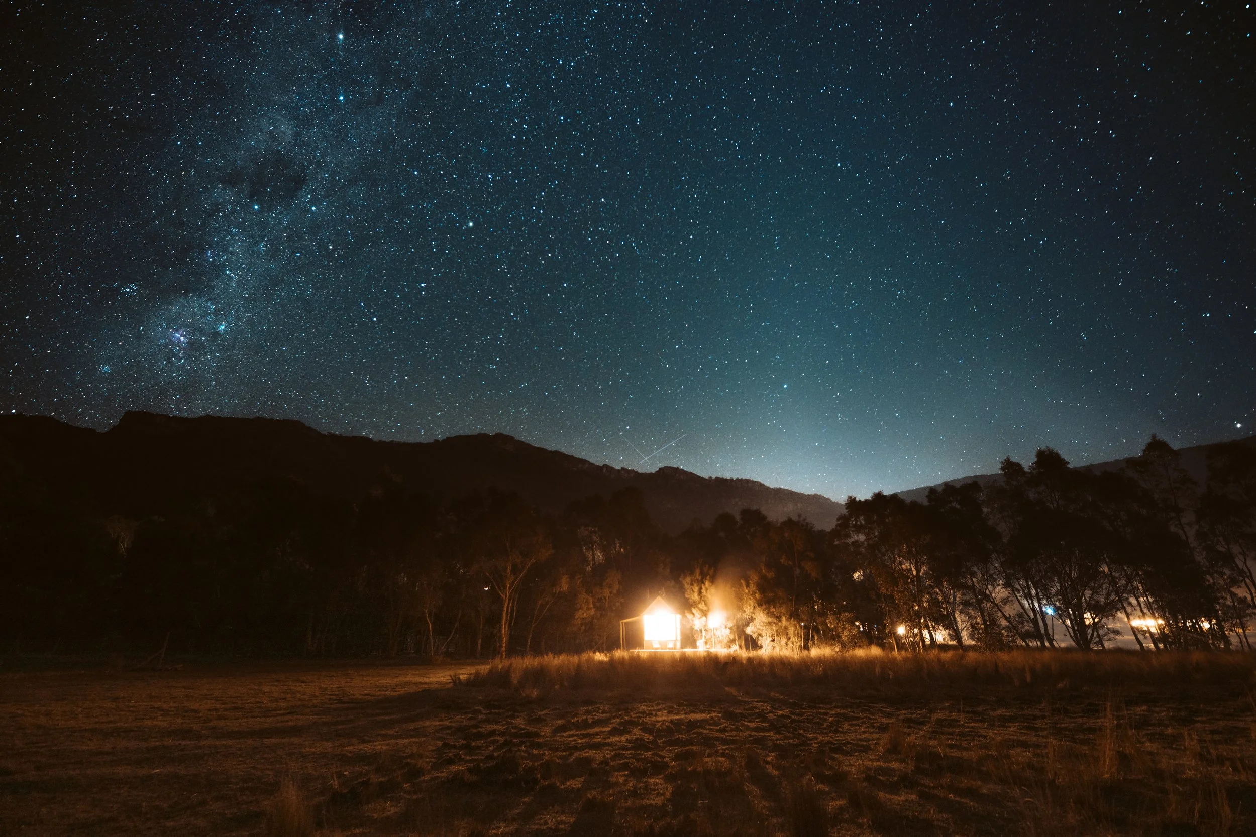 Tiny off-grid hut glowing beneath the Milky Way near Halls Gap in the Grampians.