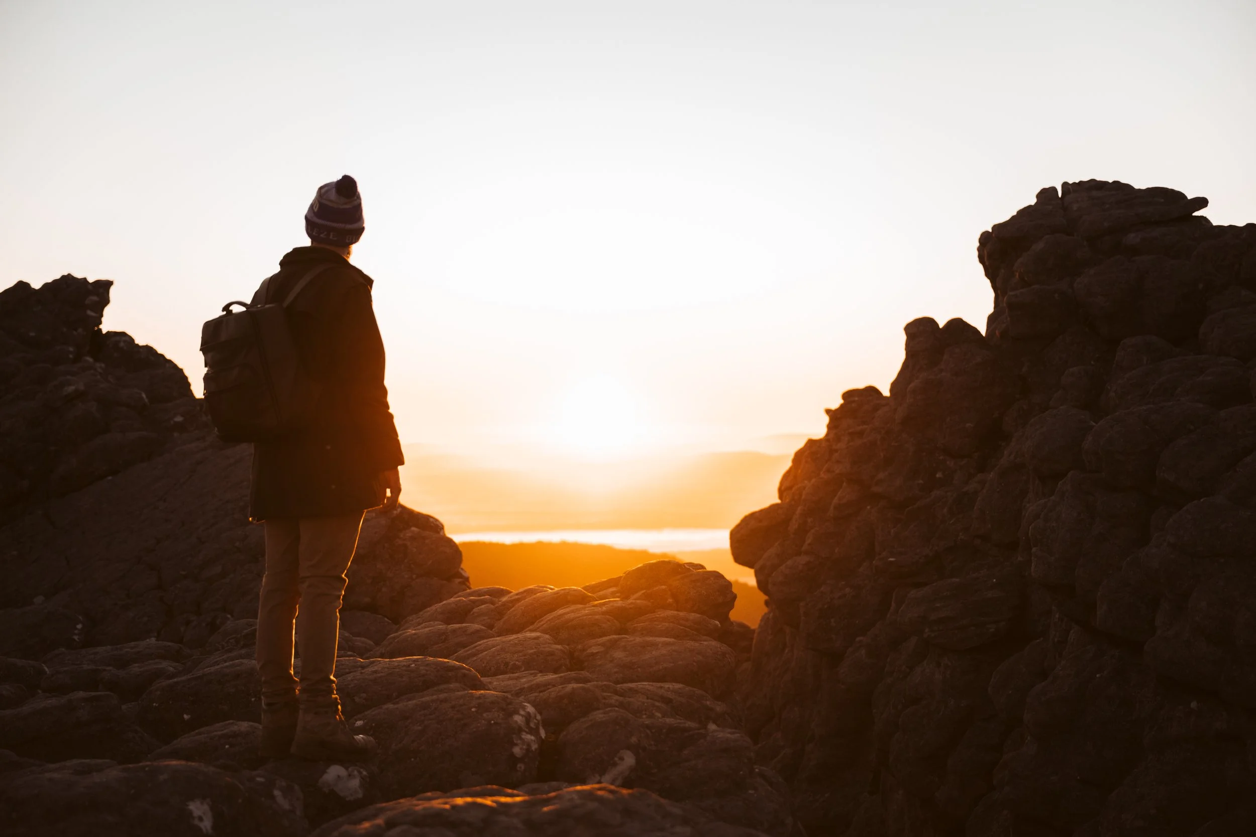Hiker watching the sunrise among the rock formations at The Pinnacle in Grampians National Park, Victoria.
