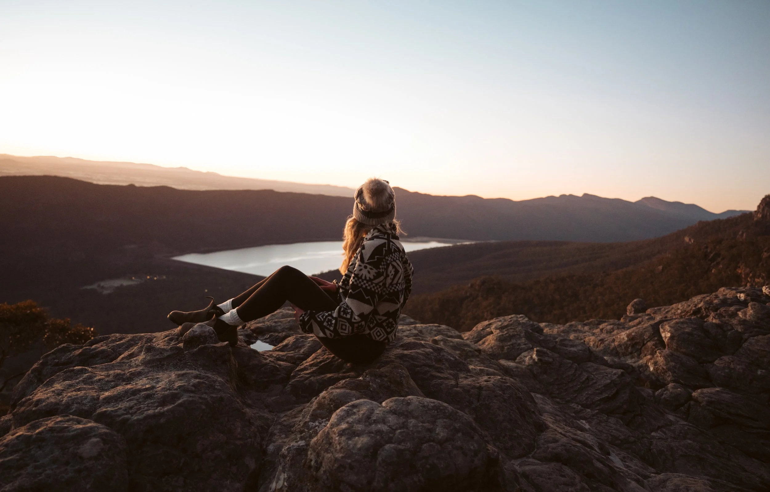 Hiker watching sunrise over the Grampians from The Pinnacle lookout in Victoria.