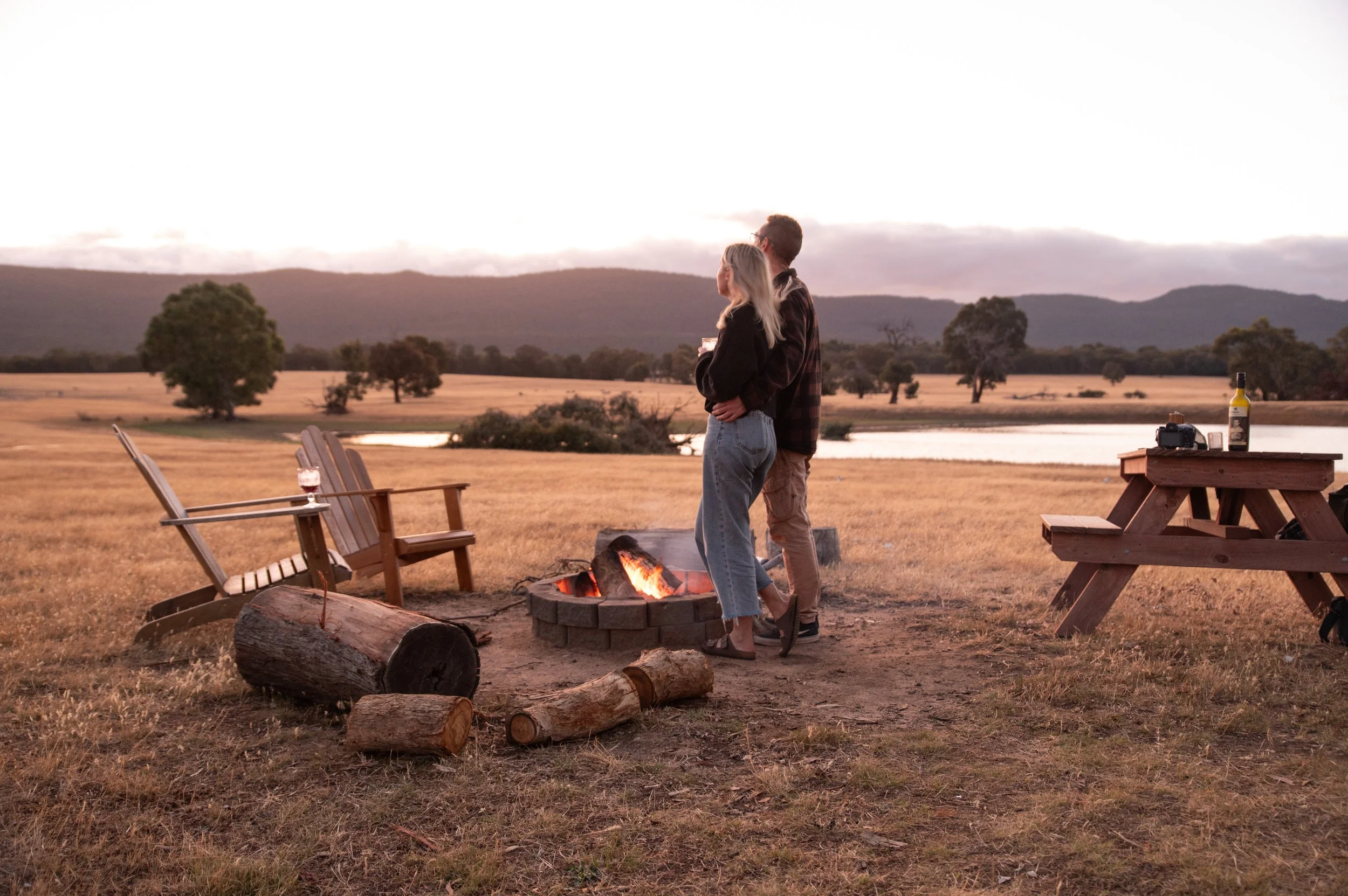 Couple enjoying sunset beside a campfire during a stay near Halls Gap in the Grampians.