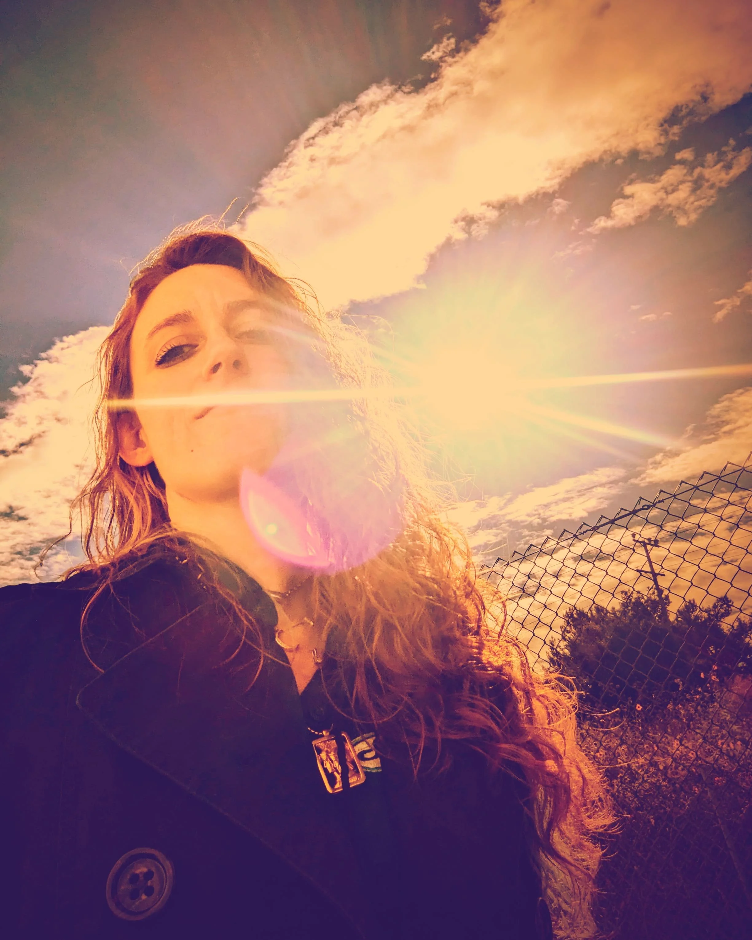 Creator of CSZZLE and Pyrite Angels photographed outdoors with golden sunlight shining across her face.