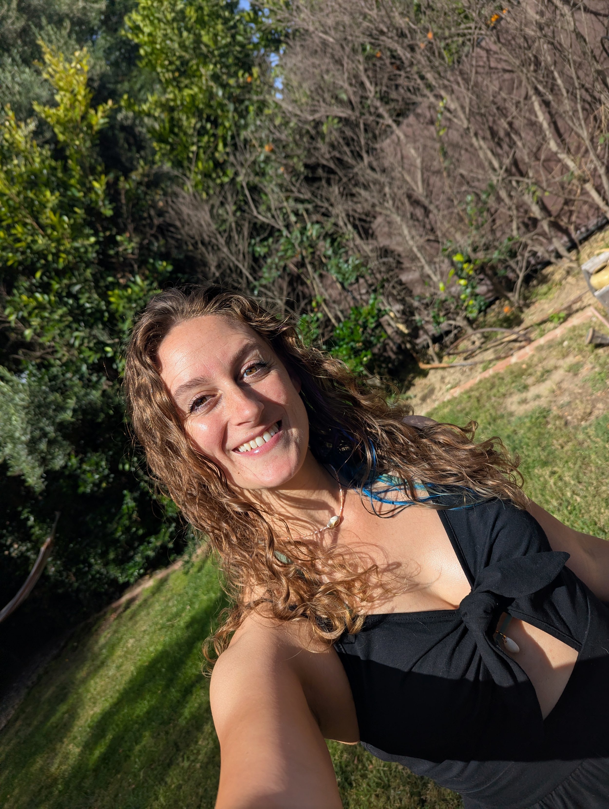 Founder of Pyrite Angels and creator of CSZZLE smiling outdoors in a green garden.