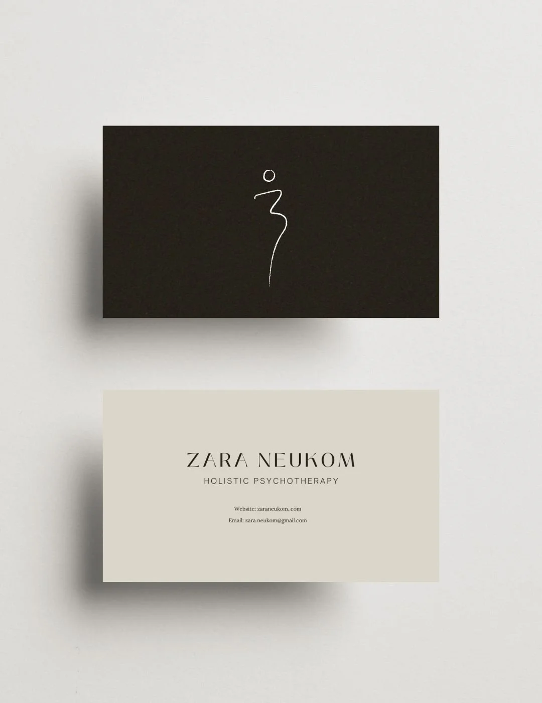 Front and back of business cards for Zara Neukom Holistic Psychotherapy. One with dark brown background and white line style logo, the other with beige background and contact information.