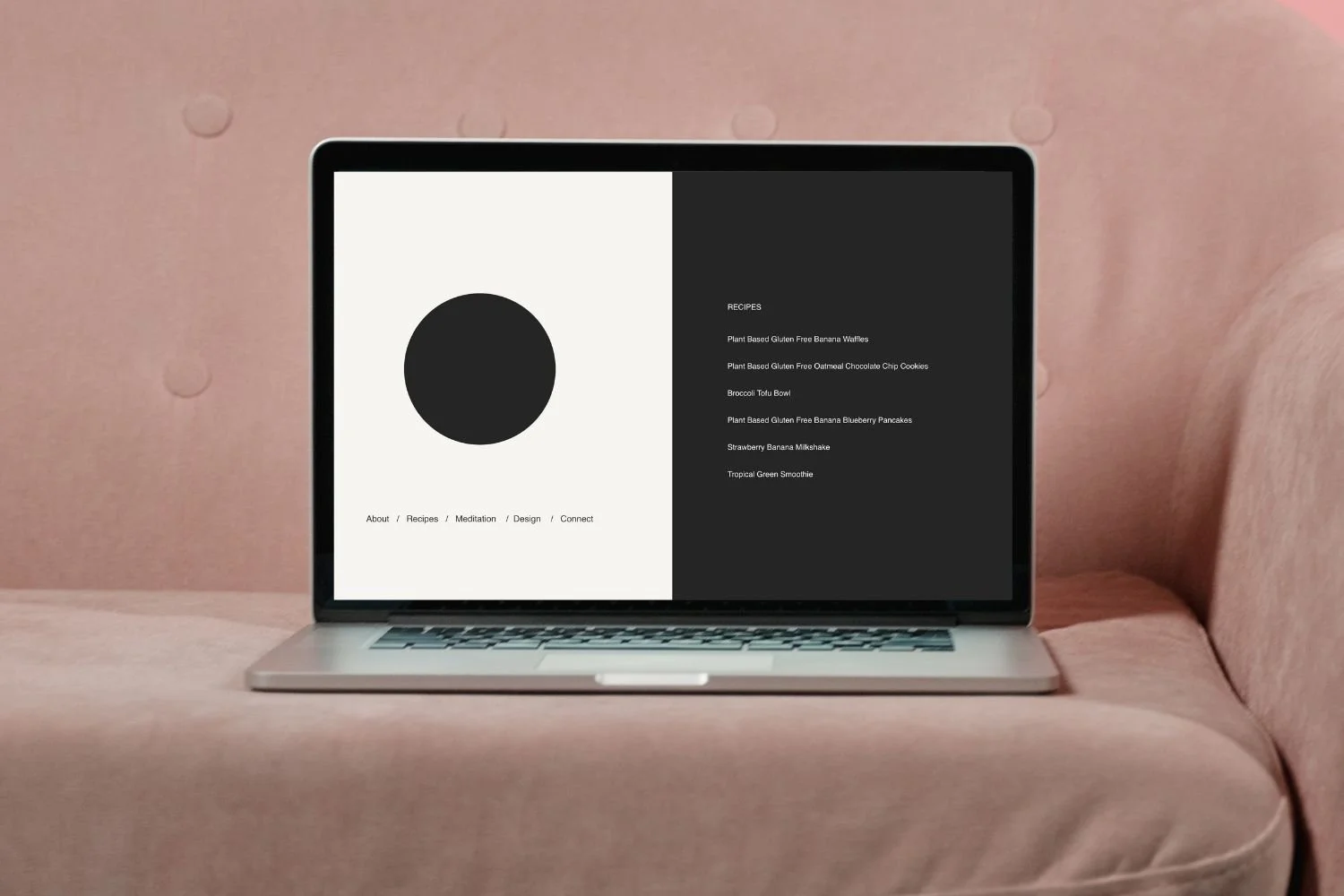 Laptop on pink sofa displaying a modern minimalist webpage with a large black circle on a white background the left and white text on soft black background on the right.
