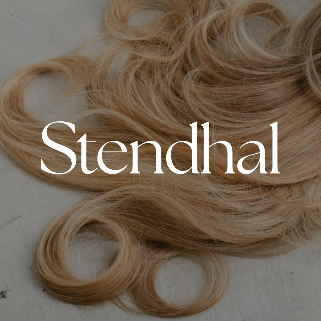Blonde curly hair extensions on a light background with the word 'Stendhal' overlaid.