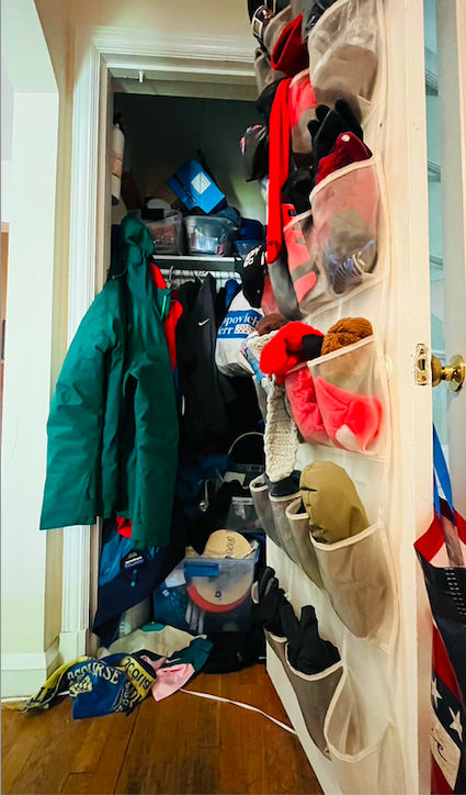 Closet mayhem with shoe organizer and clothes spilling out.