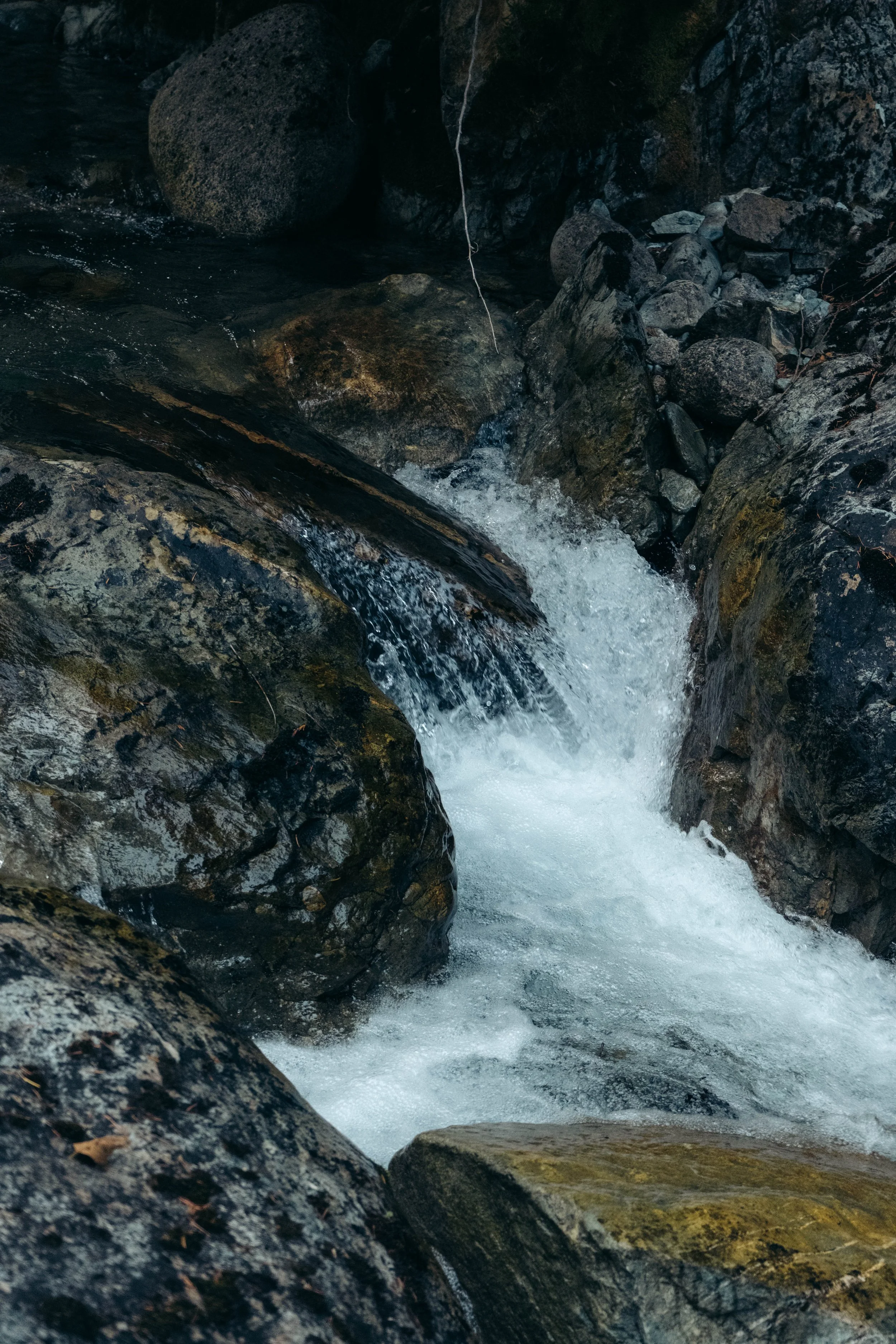 A small waterfall cascading over rocks in a rocky stream.