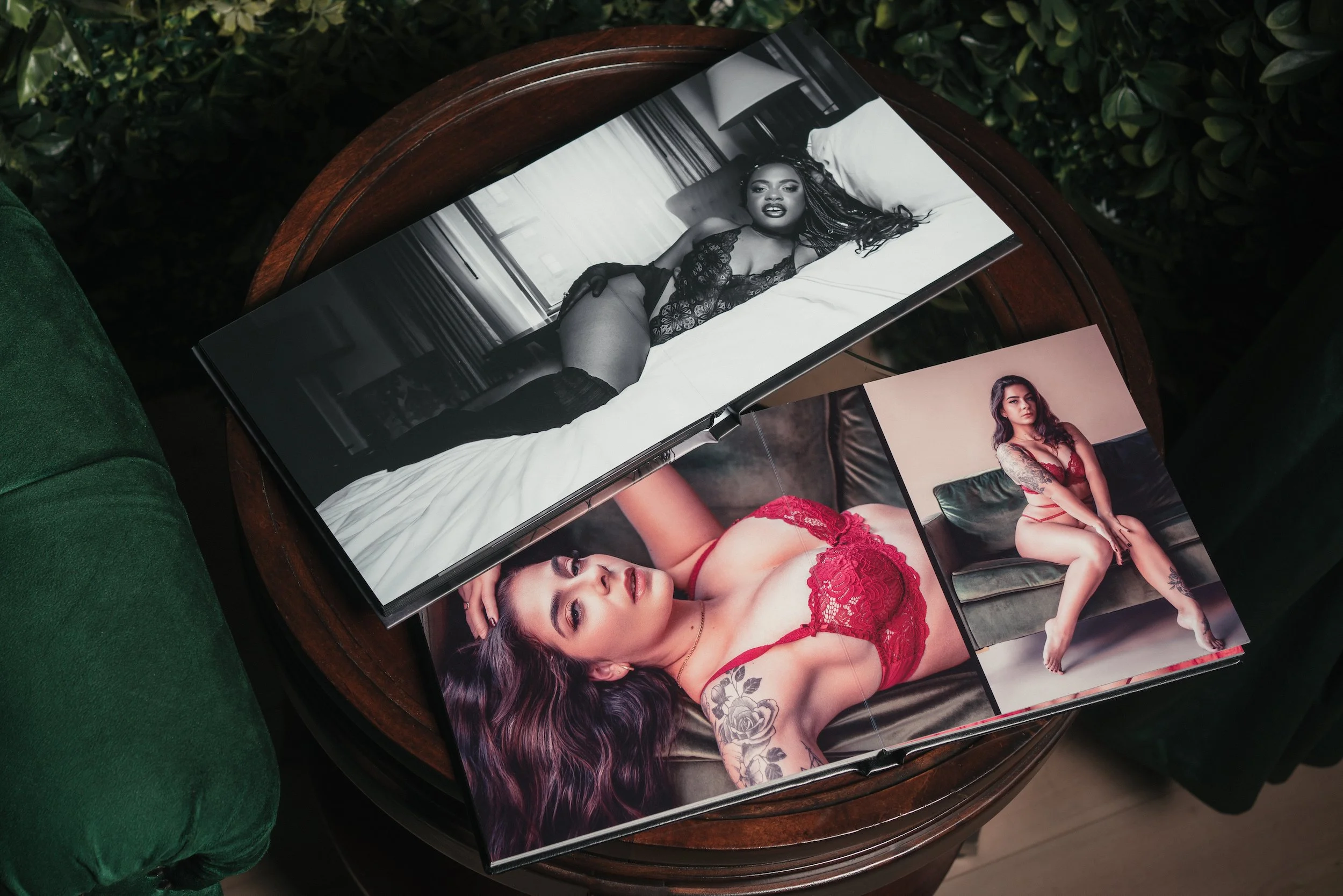 Open boudoir photo album on table showing professional portraits of women in lingerie