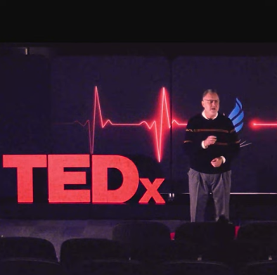 Dr. Kevin Dieter, hospice physician and educator, on a stage making a Tedx presentation on the Celtic tradition of embracing death and dying, and the journey of his own education on end-of-life matters.