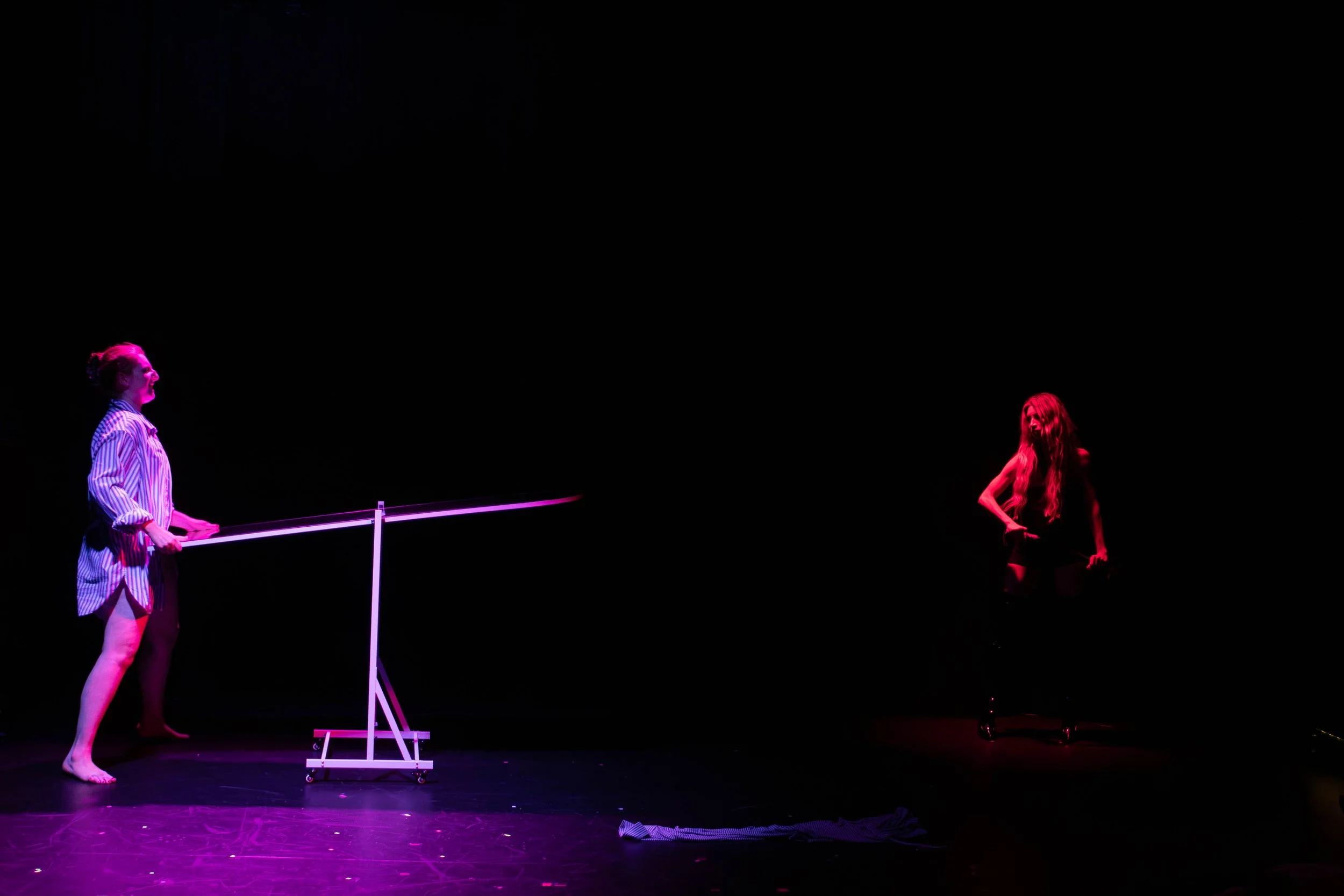 Vanessa Meyer performing on a dark stage opposite a co-star.
