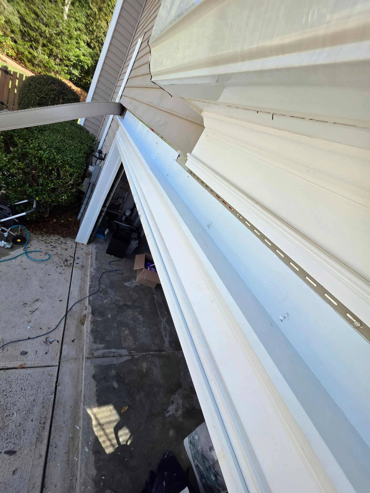 Close-up of flashing along the garage-door trim, installed as part of the header and exterior trim repairs to help direct water away from the opening.