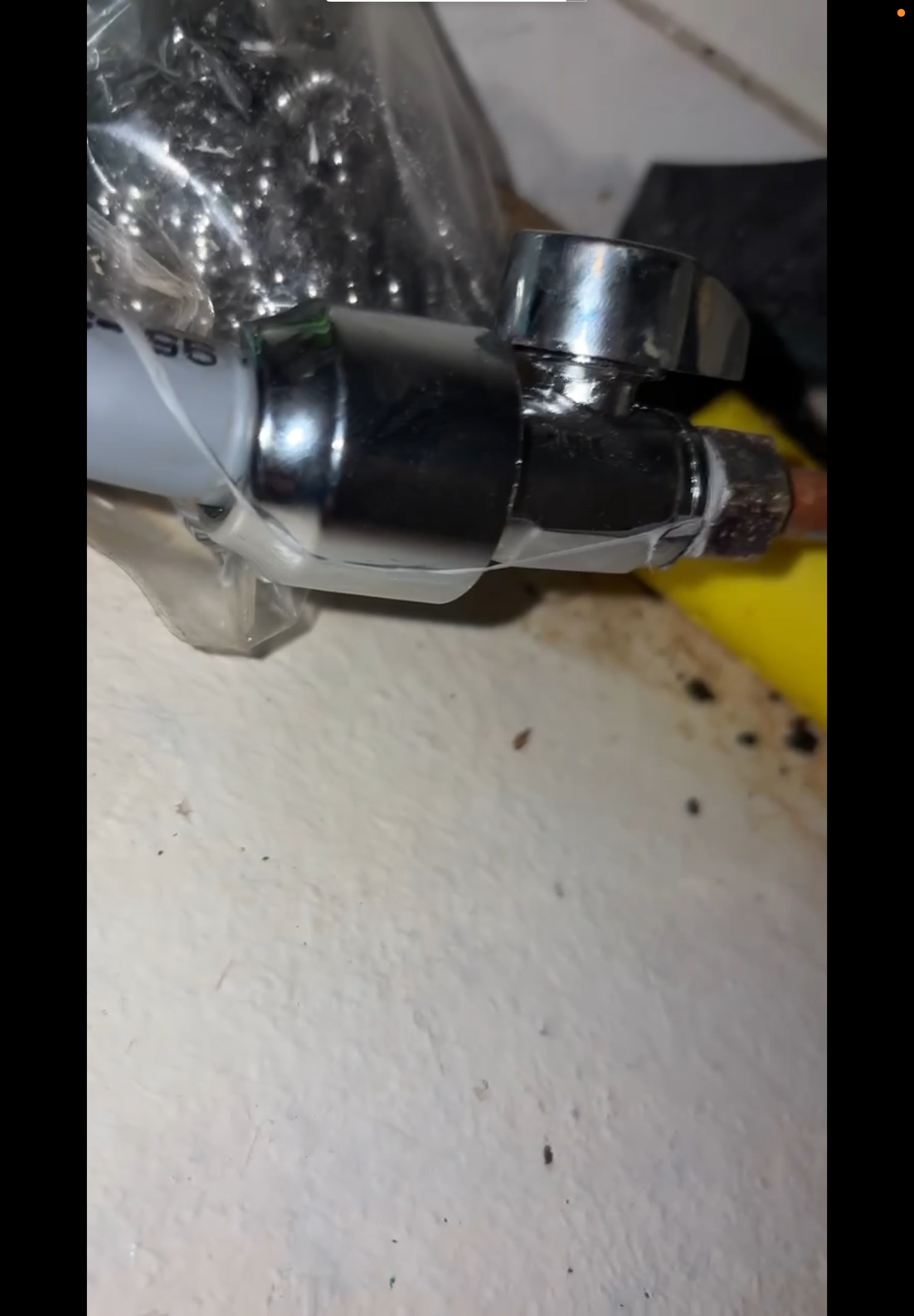 Close view of plumbing fittings and a pipe connection.