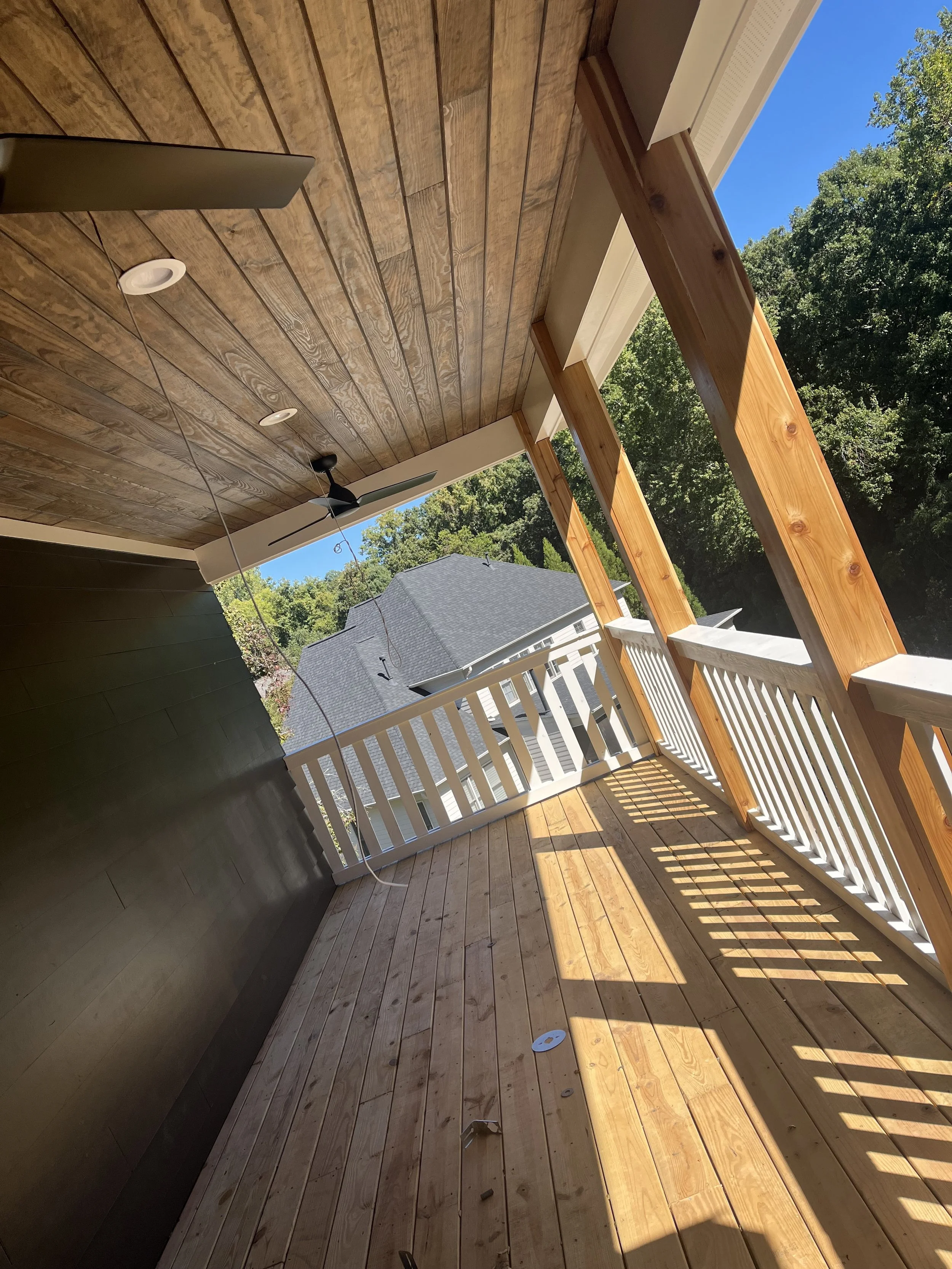 Deck staining project with wood decking, porch ceiling, and railings.