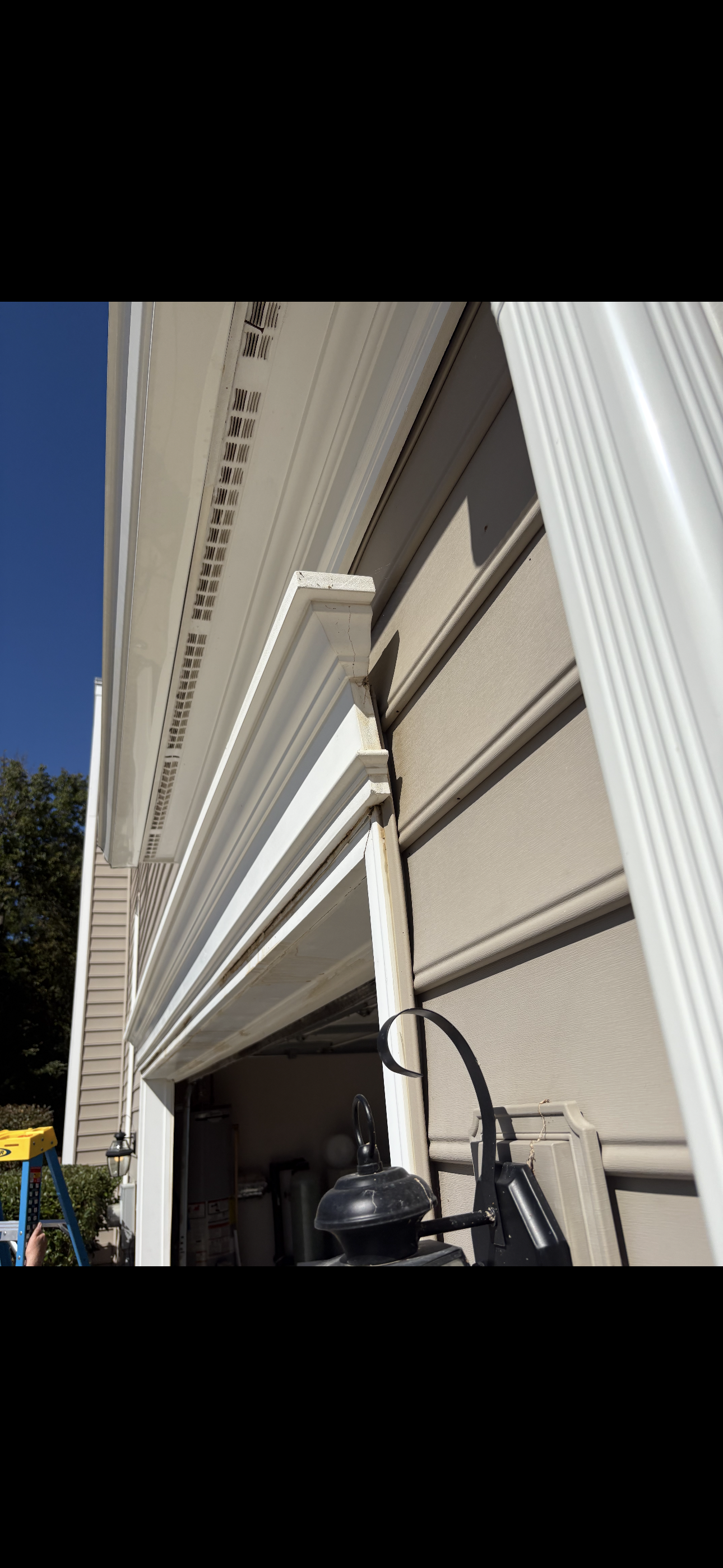 Close-up of the existing garage-door exterior trim and siding junction before corrective trim, header and flashing repairs.