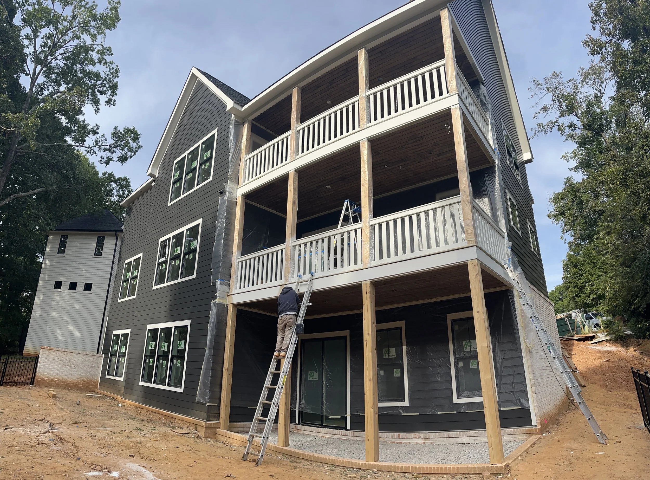 Exterior painting project on a multi-level home with stacked porches.