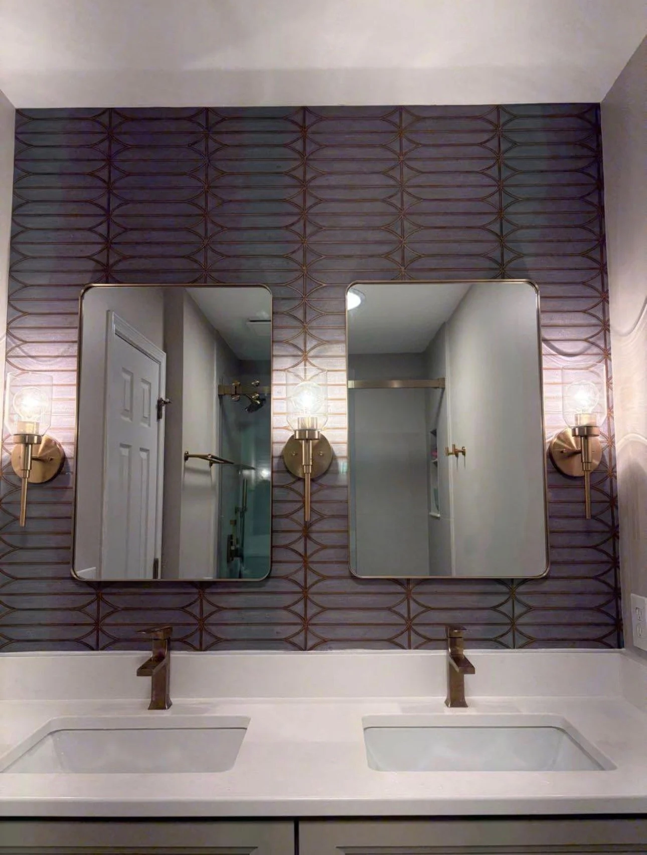 Bathroom vanity area with mirrors, wall tile, and light fixtures.