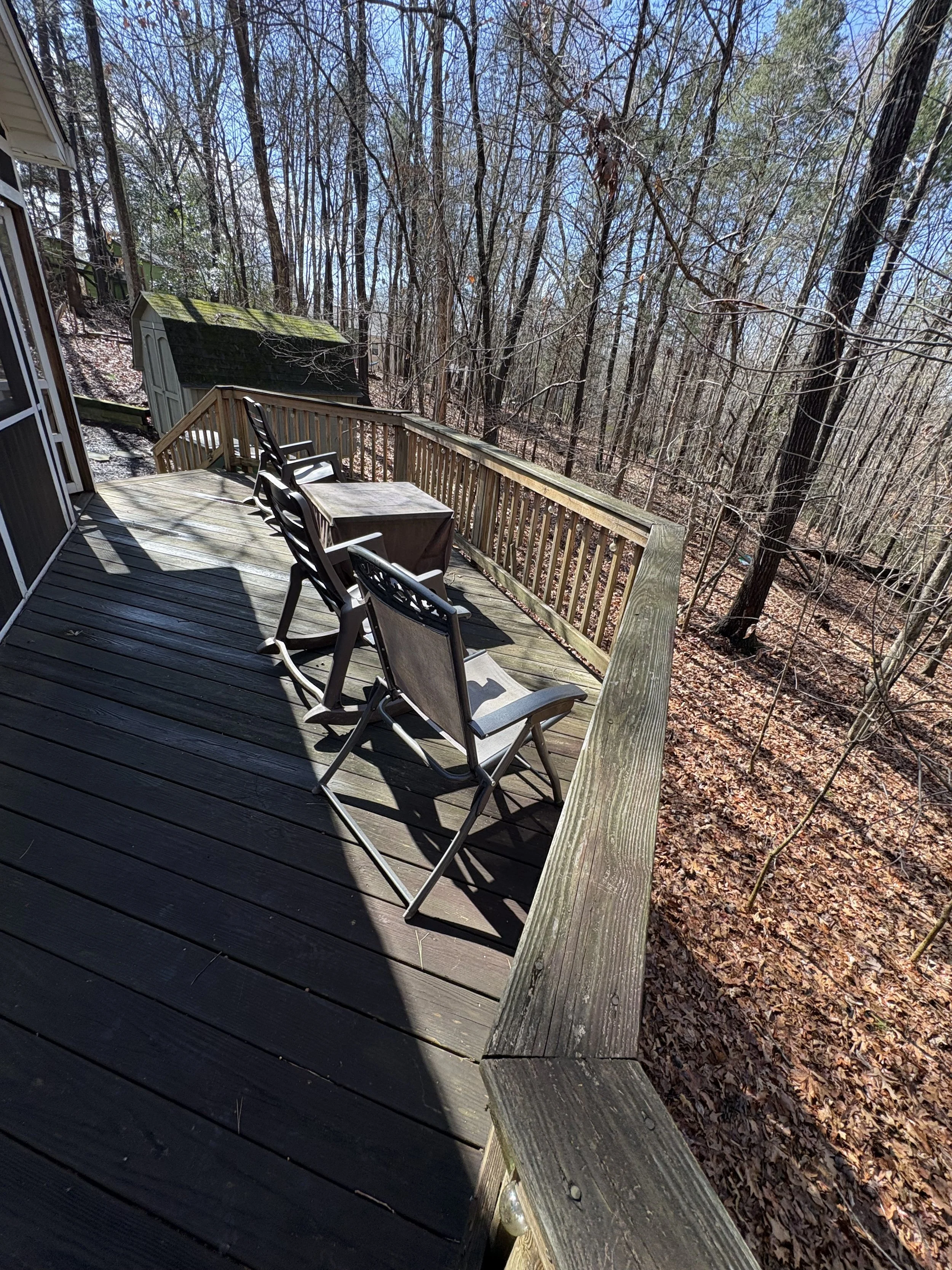 Wood deck and railing overlooking the wooded yard.