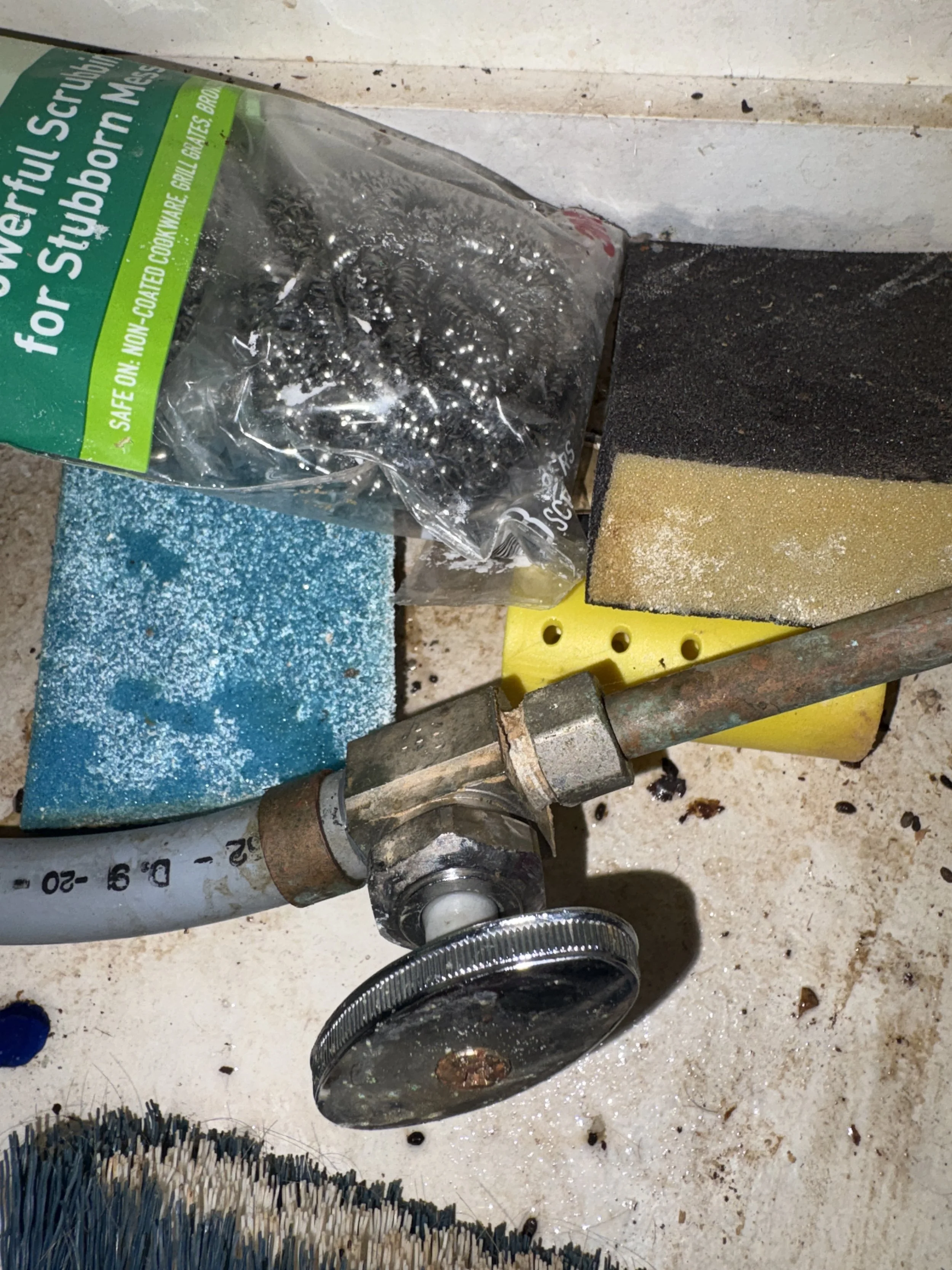 Close view of a plumbing shutoff valve and pipe connection during repair work.
