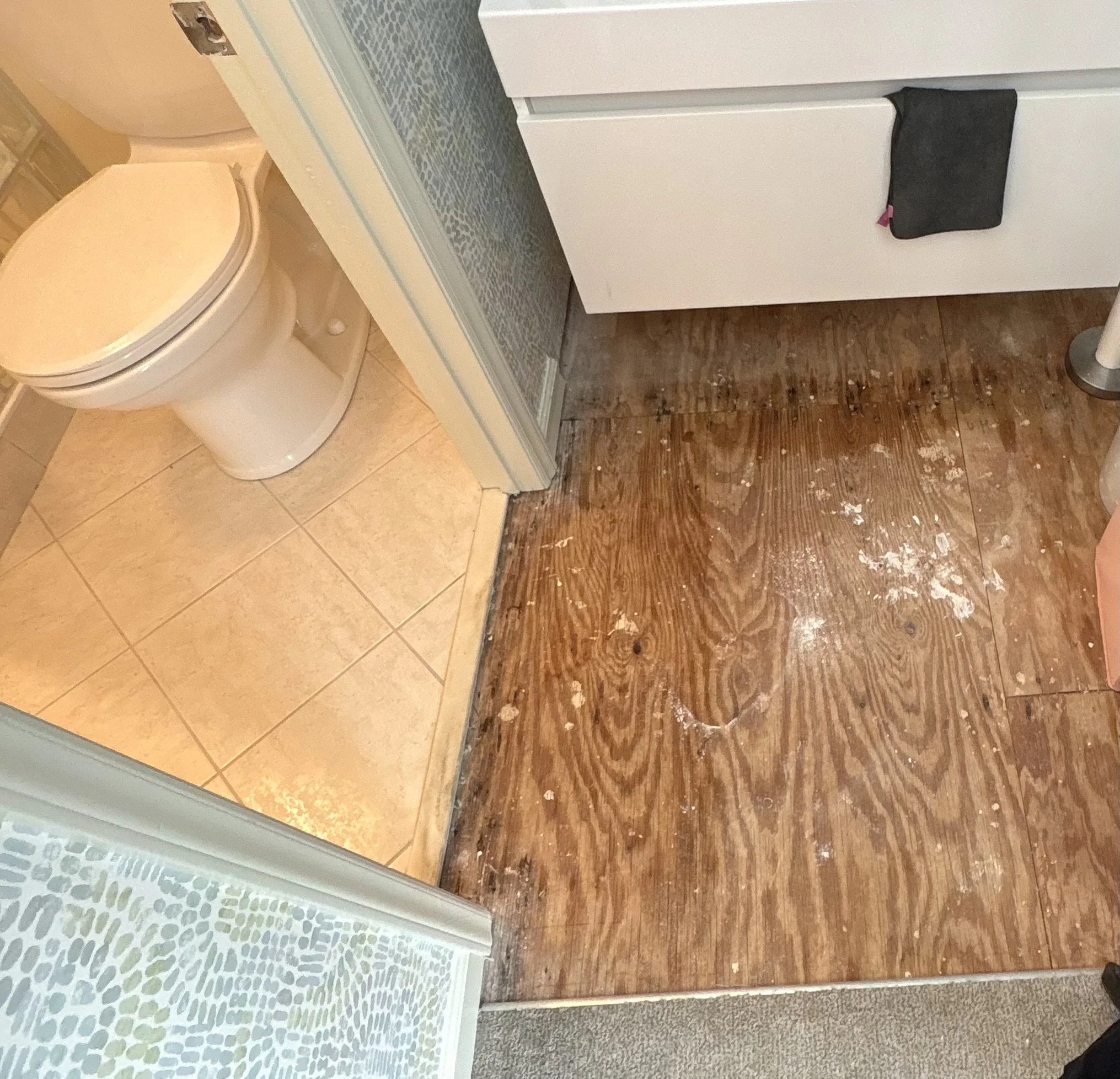 Bathroom floor with the subfloor exposed before new flooring.