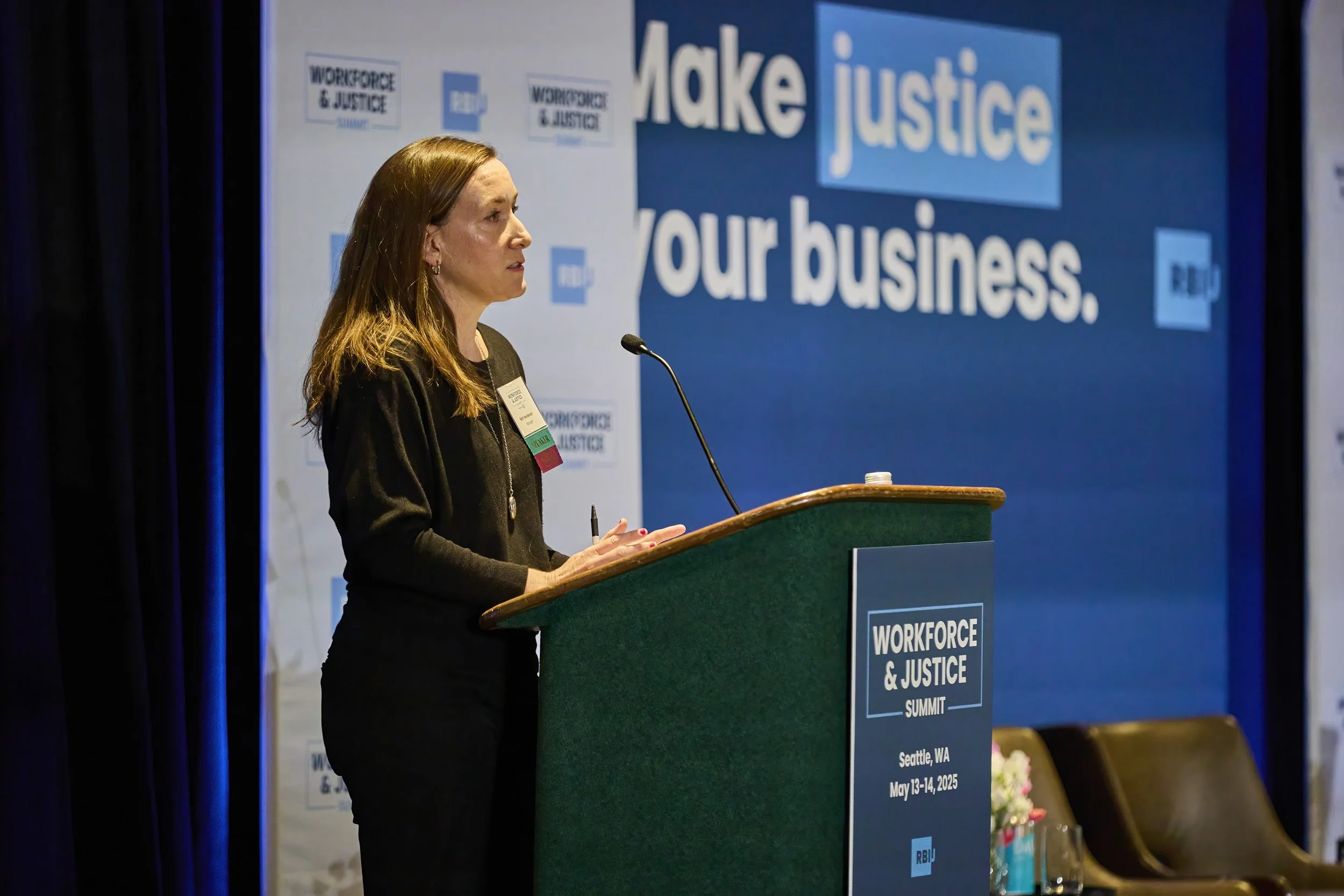 Beth Henderson, Assistant General Counsel and Director of the Microsoft Pro Bono Program, gives opening keynote at podium at the Workforce & Justice Summit