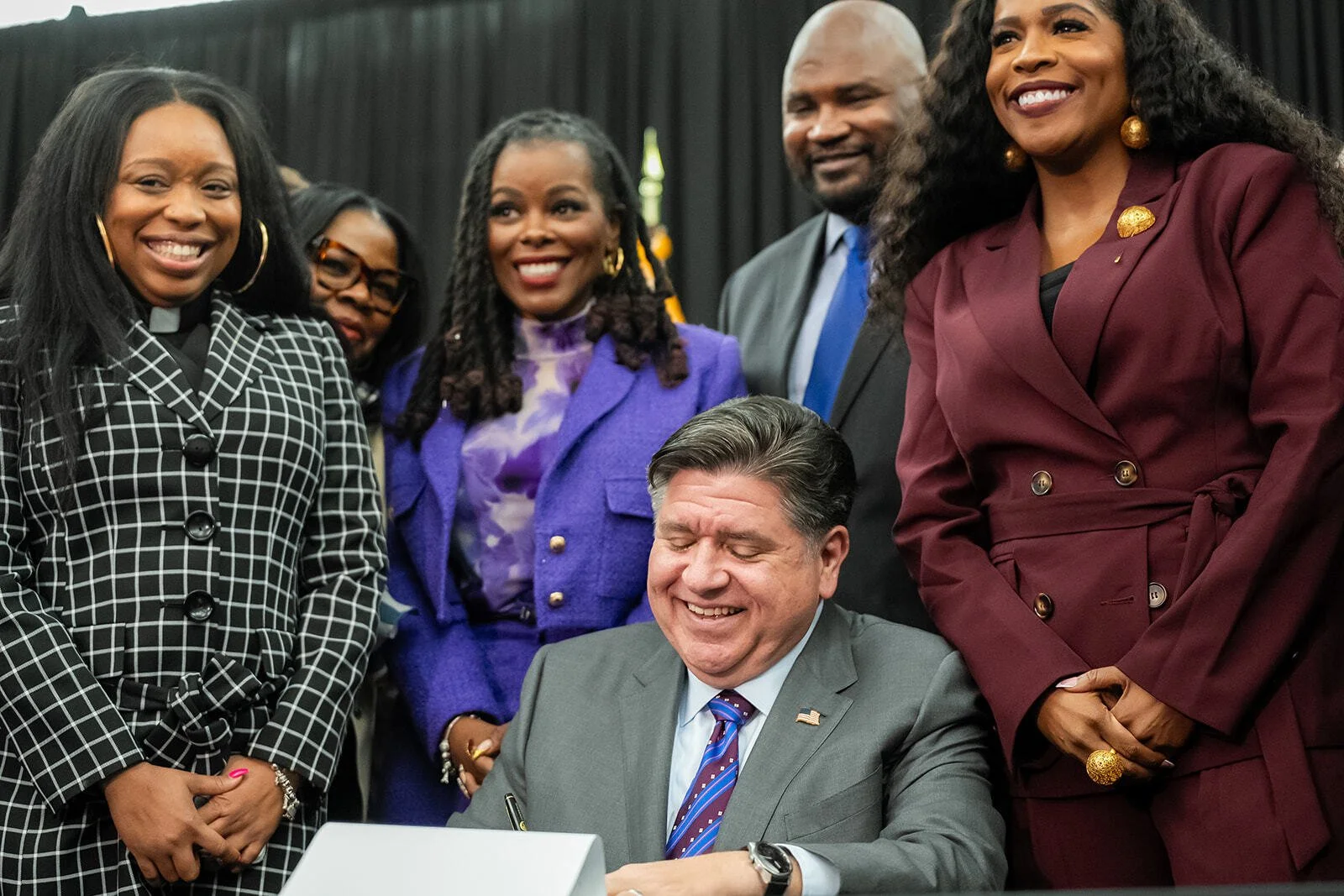 Advocates surround Illinois Governor JB Pritzker at the signing of the state's Clean Slate Act