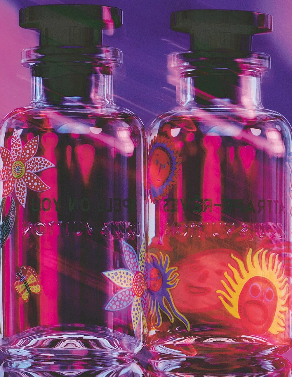 Two clear glass bottles with colorful flower, sun, and butterfly stickers, reflecting pink and purple lights.