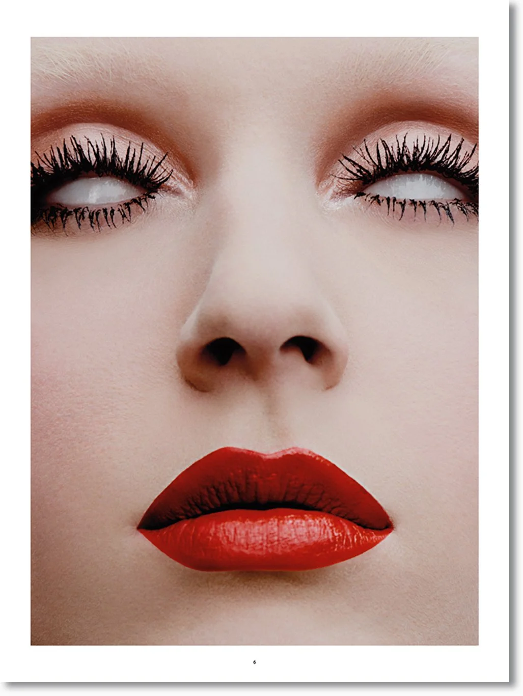 Nahaufnahme eines Gesichts mit rotem Lippenstift, Mascara und hellhäutiger Haut, Frau mit geschlossenen Augen