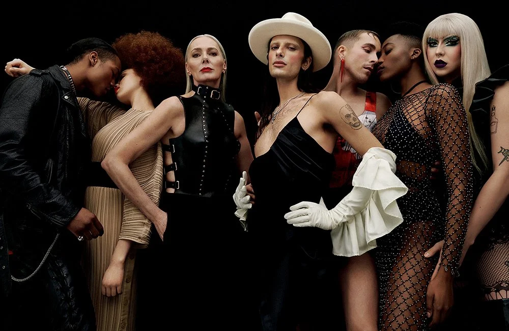 Gruppensexy Frauen in auffälligen Outfits posieren gemeinsam vor schwarzem Hintergrund