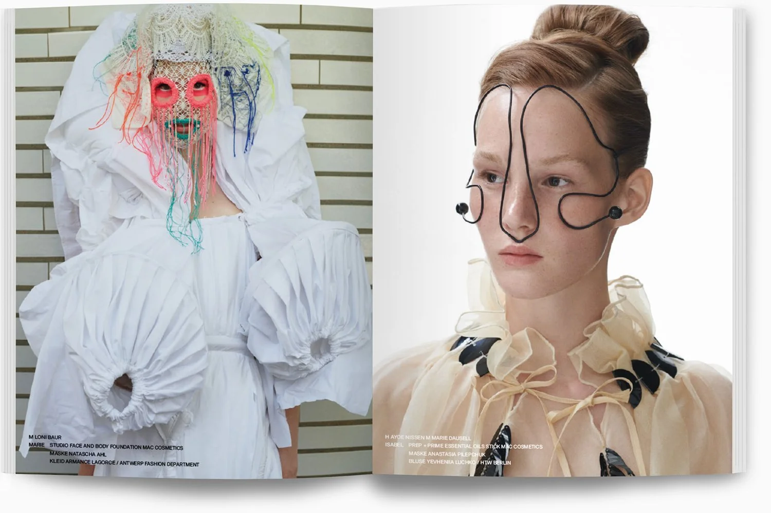 Kunstvolle Modenschau mit avantgardistischen Kostümen; links eine Person in einem weißen, voluminösen Kleid mit farbigen Schnüren, die das Gesicht maskieren, rechts eine Person in einem transparenten beige-gelben Kleid mit schwarzen Akzenten, beide M
