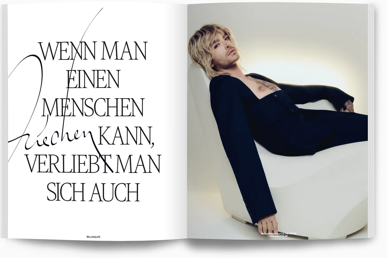 Doppeltes Seitenlayout mit Text auf der linken Seite und einem liegenden Mann auf der rechten Seite, der schwarze Kleidung trägt, längliche blonde Haare hat und in einer weißen Wanne liegt.