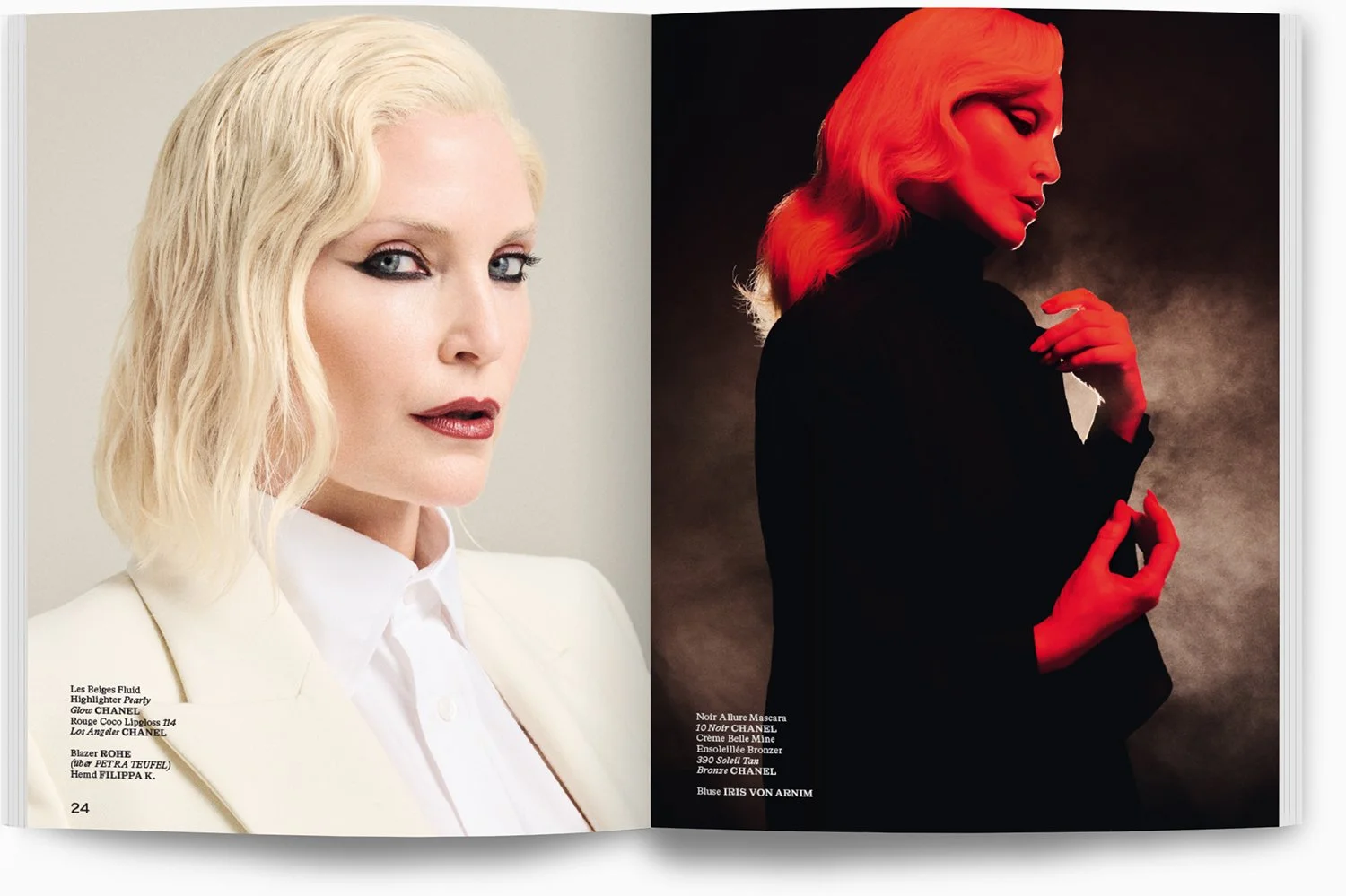 Zwei Frauen, die sich in einem Magazin befinden. Die linke Frau hat hellblonde, lockige Haare und trägt ein weißes Sakko. Die rechte Frau hat rote Haare, trägt schwarze Kleidung und steht vor einem dunklen Hintergrund mit rotem Licht.